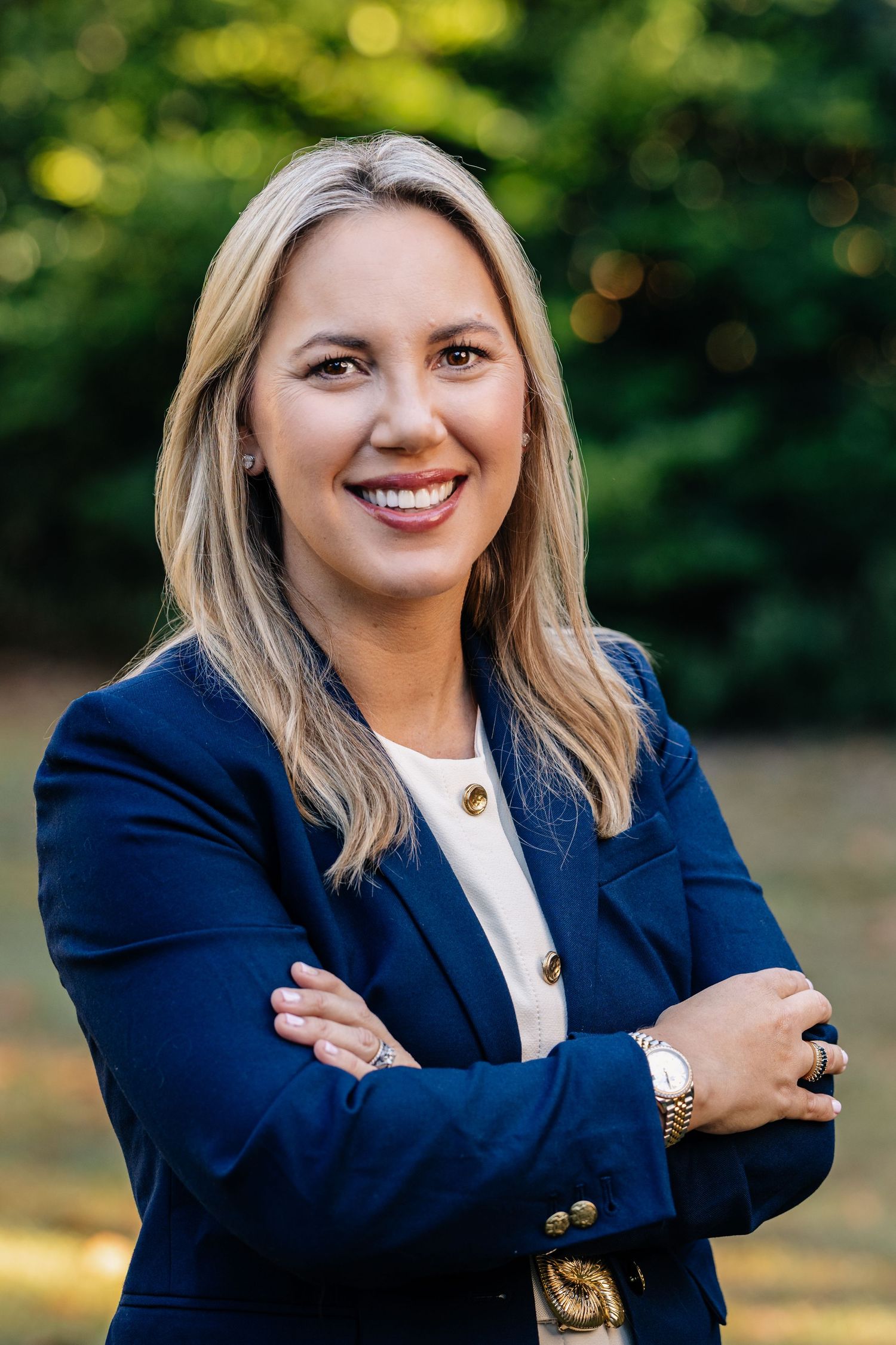 Professional portrait series showing someone in a navy blazer and white top against a blurred outdoor background.
