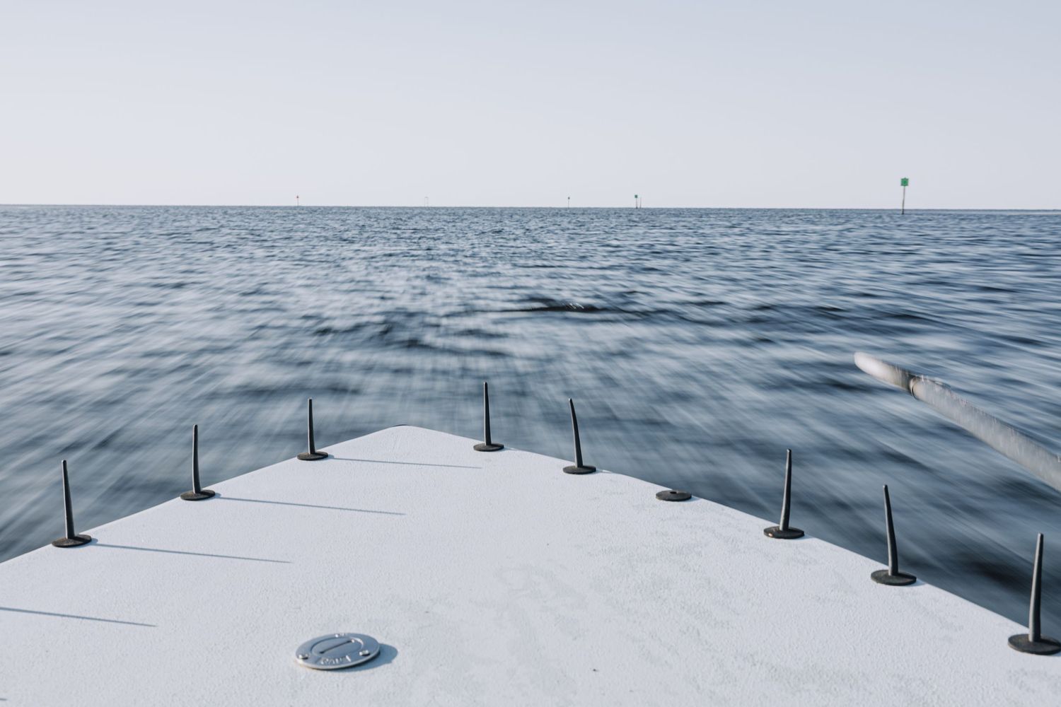 Series of shots showing calm ocean waters with fishing poles mounted on a boat.