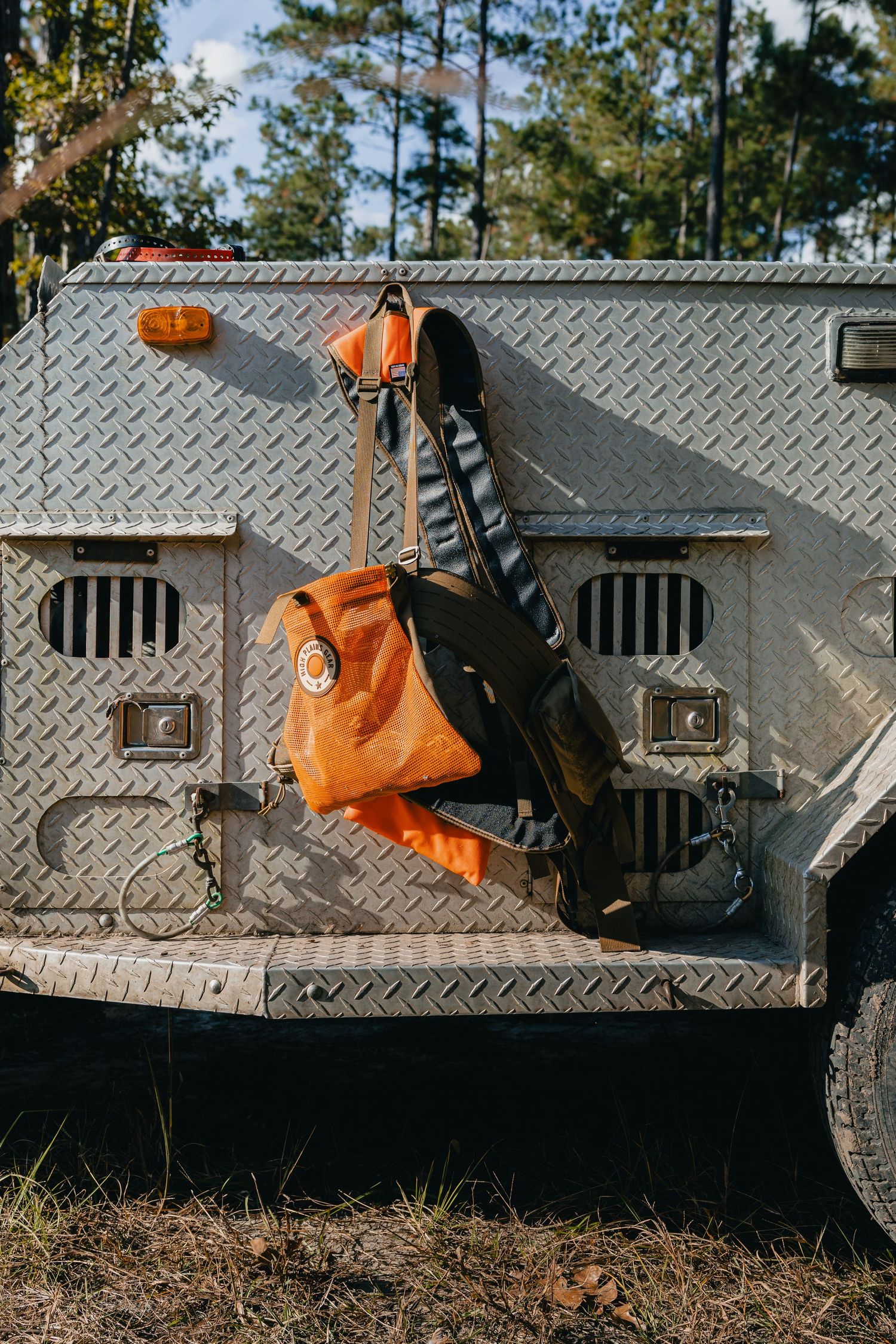 Hunting dog kennel with diamond plate metal surface mounted on vehicle.