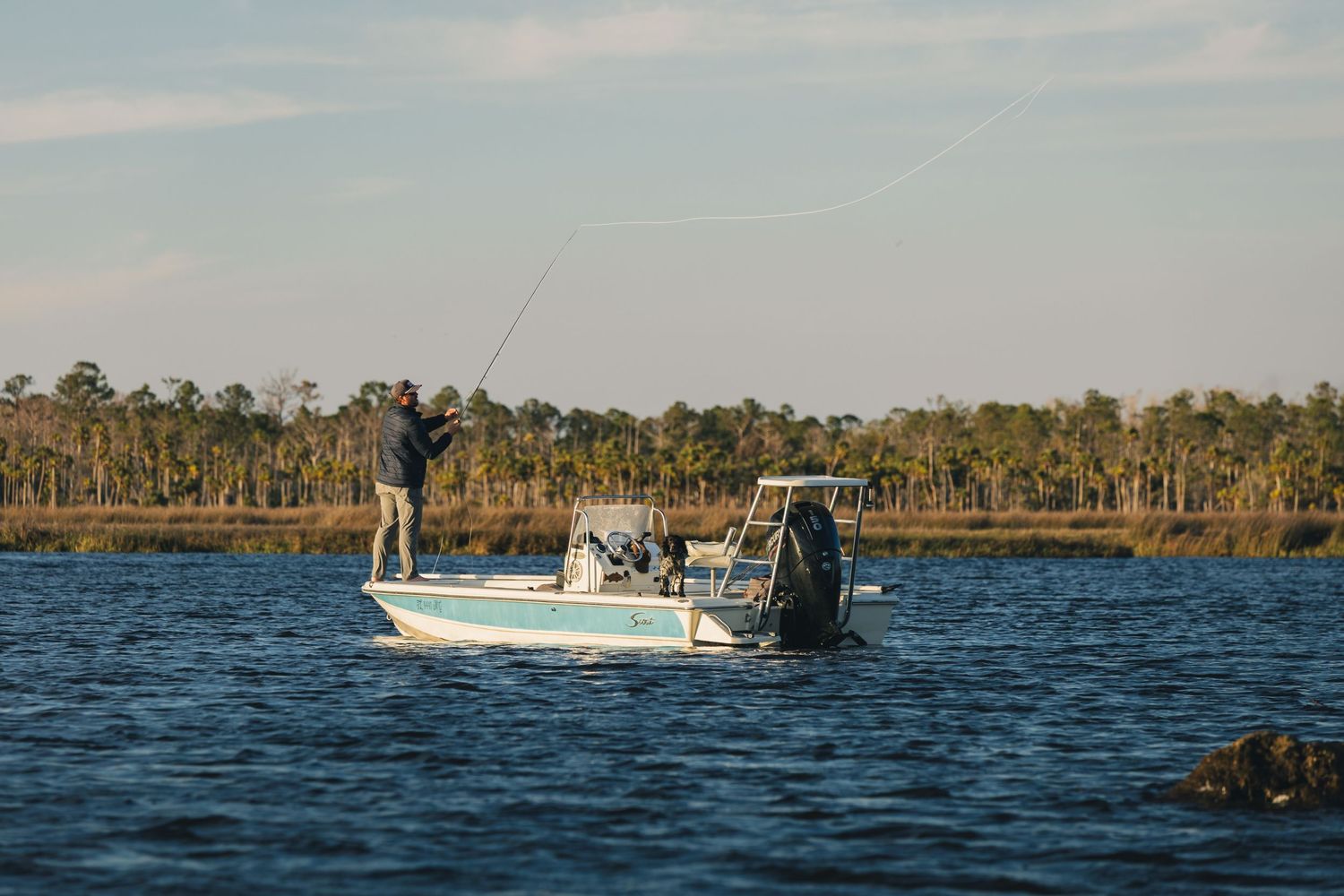 Fishing boats navigate through coastal waters on a sunny afternoon.