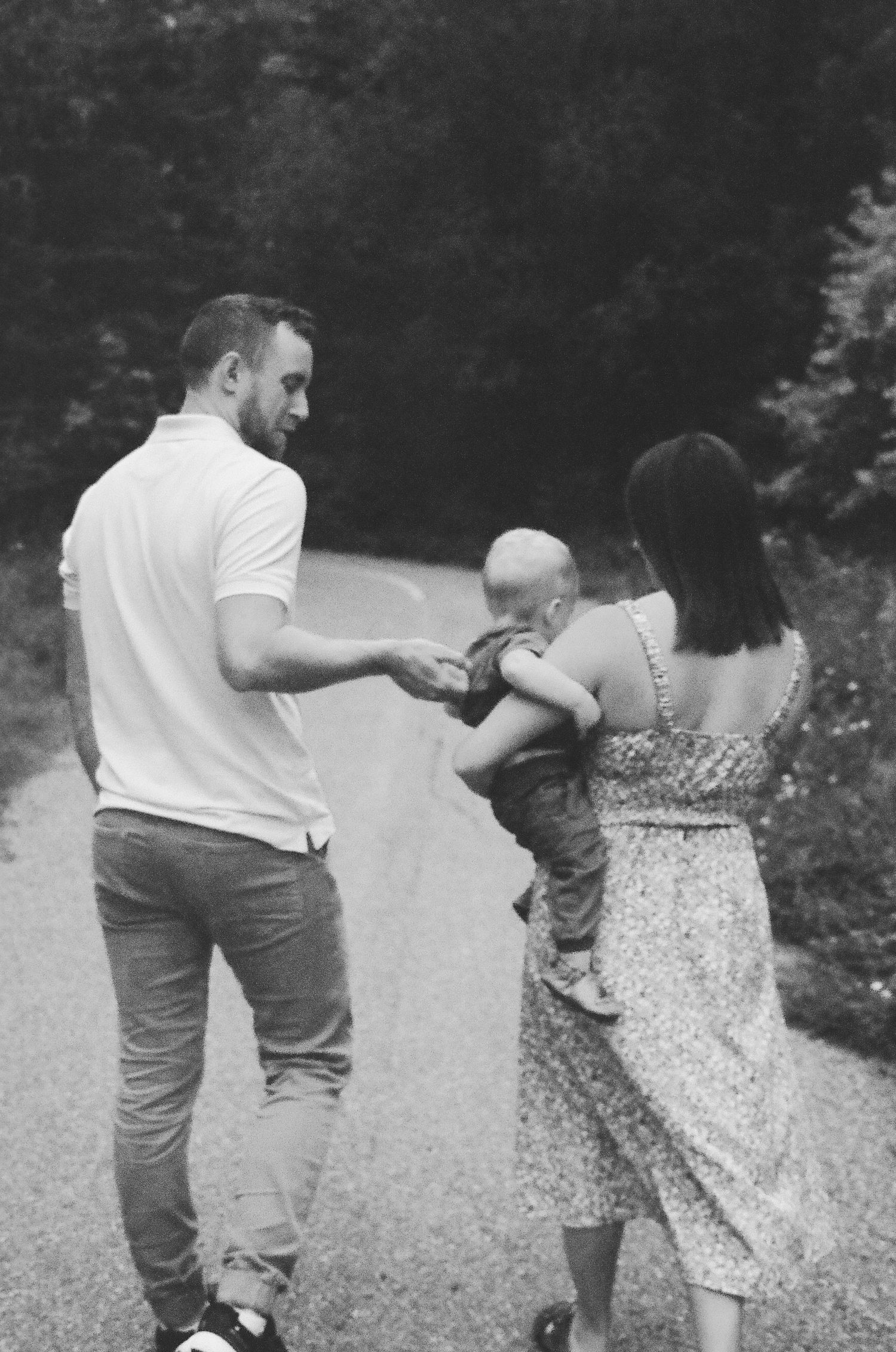 A sequence of black and white photos showing a couple holding hands and walking together on a gravel path.