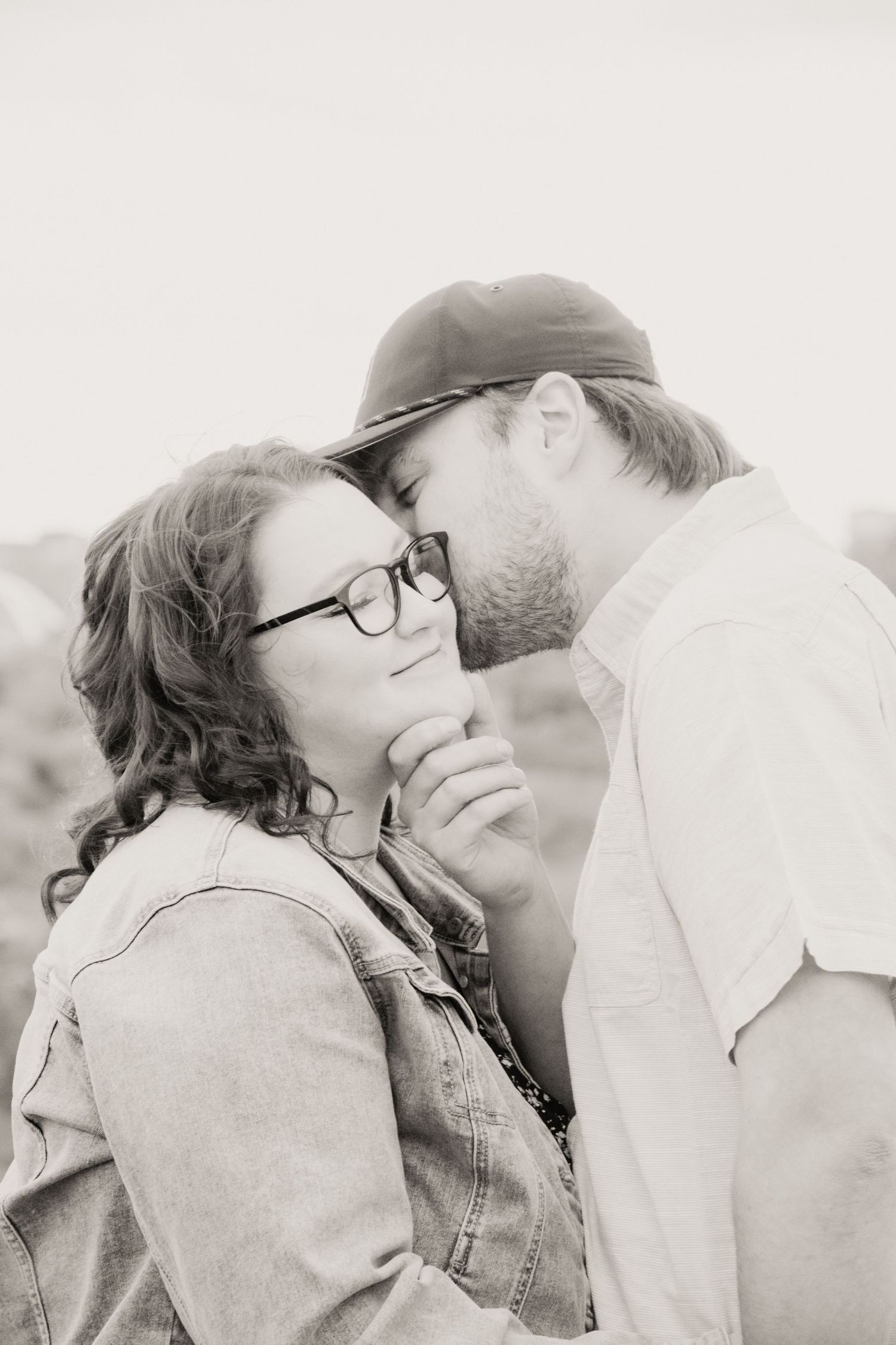 A romantic black and white photo series showing four tender moments between a couple in soft lighting.