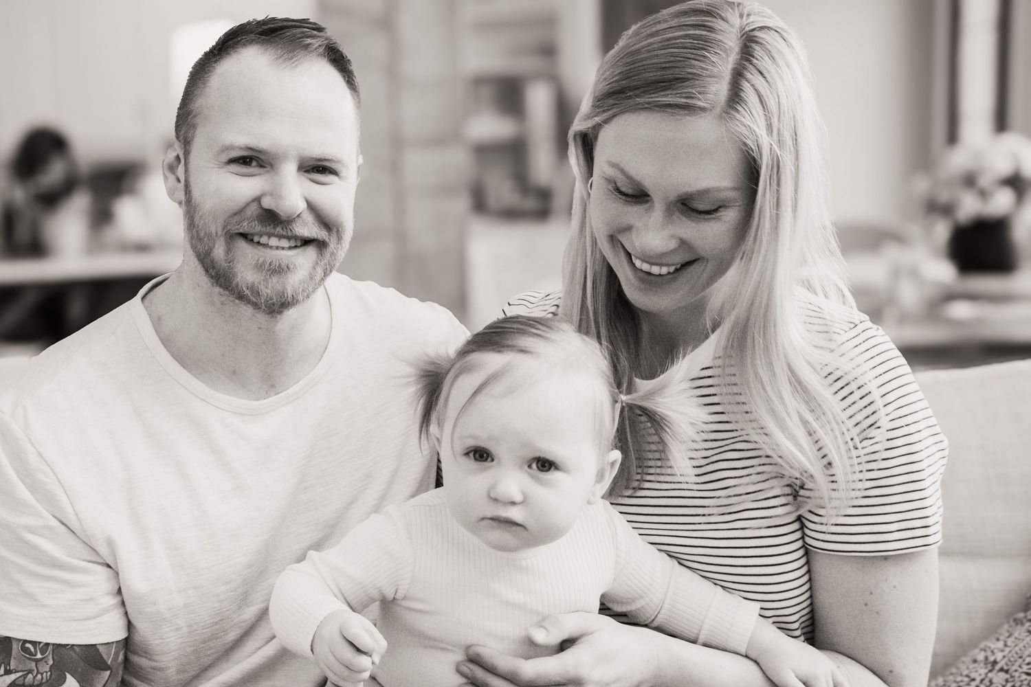 Black and white photo series of a loving family enjoying tender moments and candid interactions together at home.