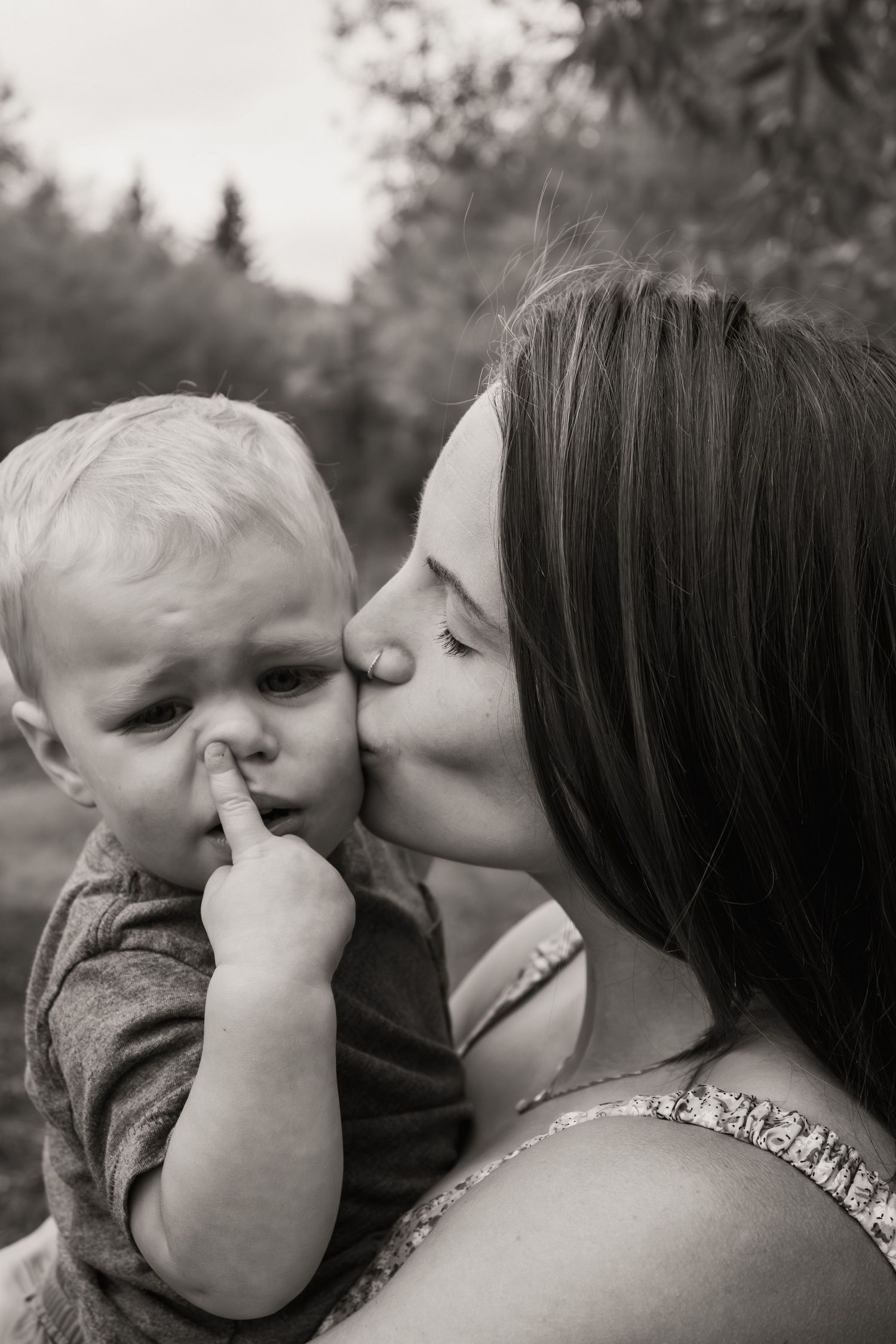 A tender black and white portrait of a sweet moment between parent and child outdoors.