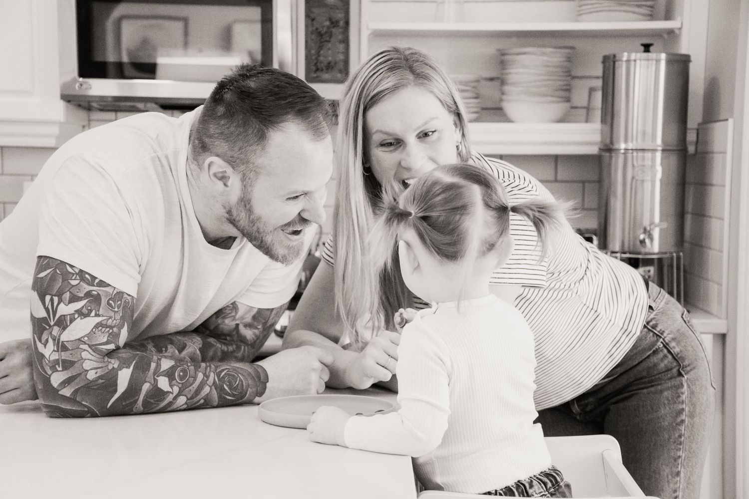 Black and white grid showing six images of parents and children in tender moments laying together.