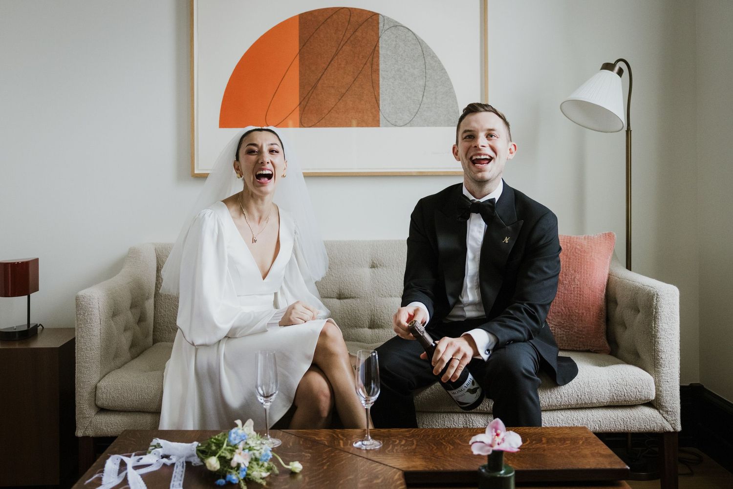 Couple opening champagne in their room at Nine Orchard in NYC