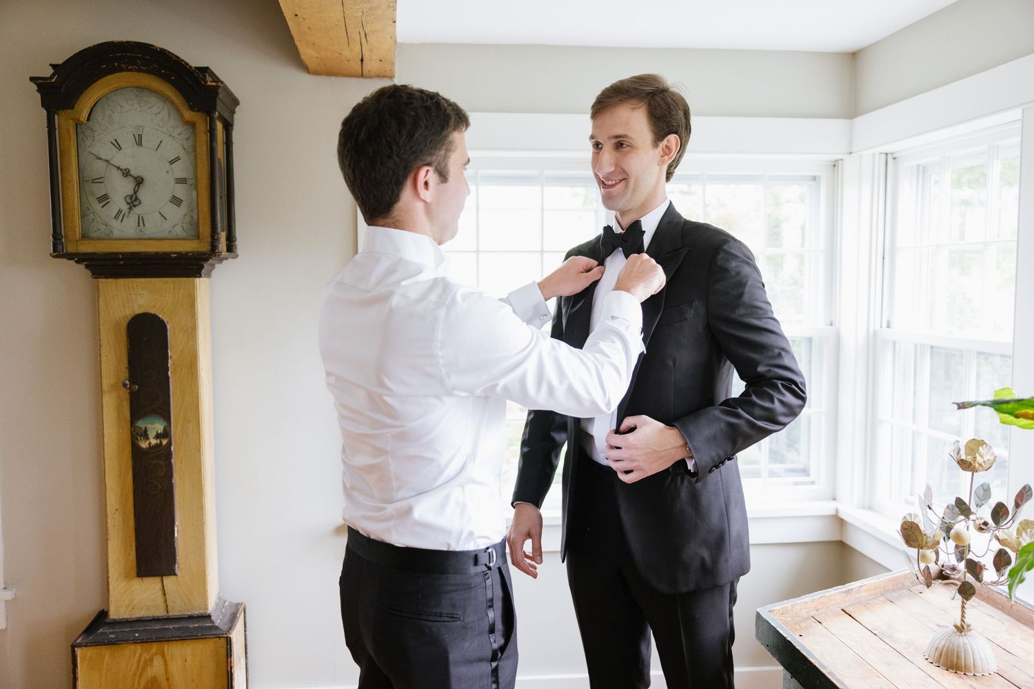 Groomsman adjusting groom's boutonniere at LionRock Farm wedding