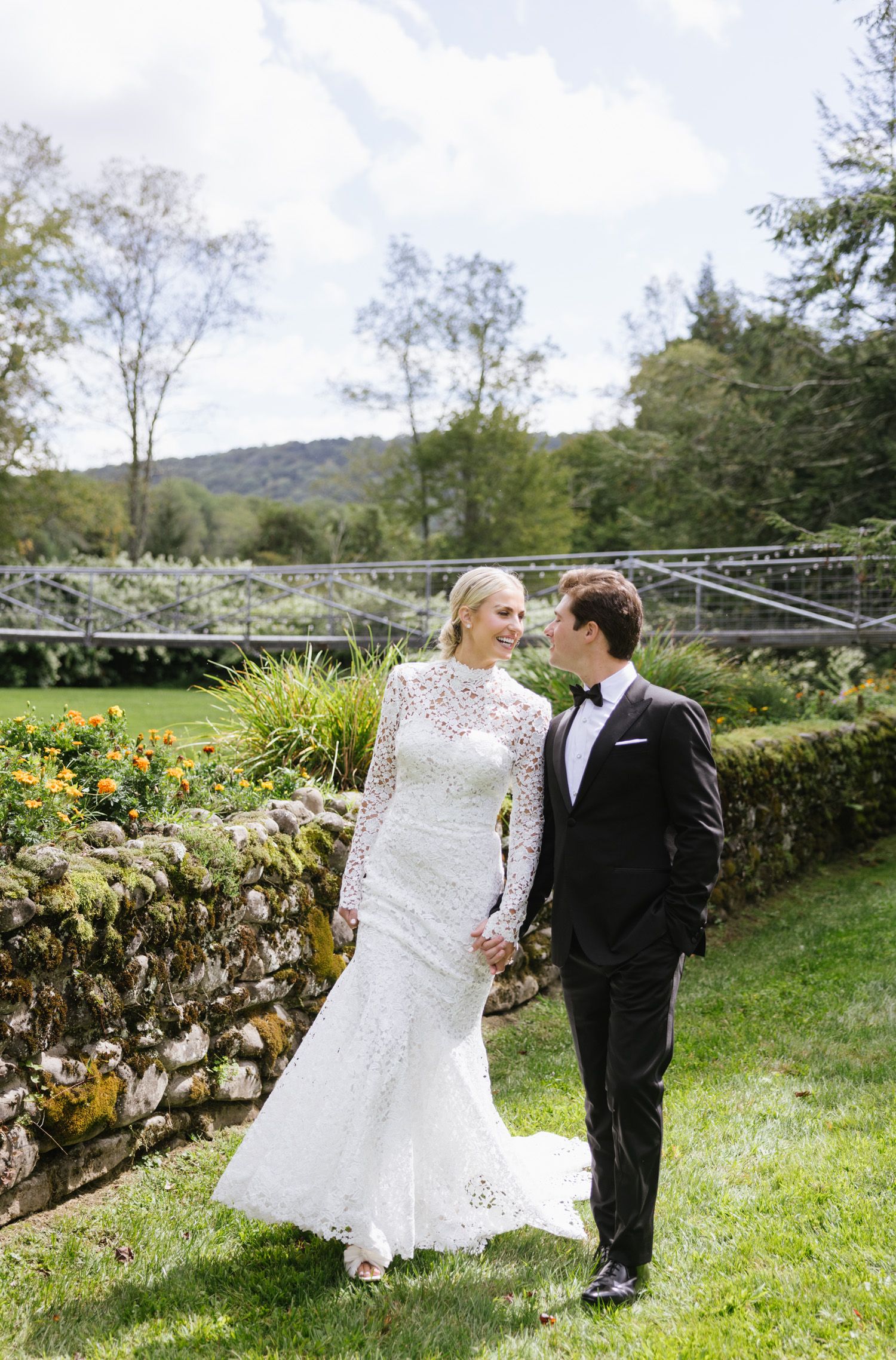 Couple holding hands and walks at Antrim Streamside wedding