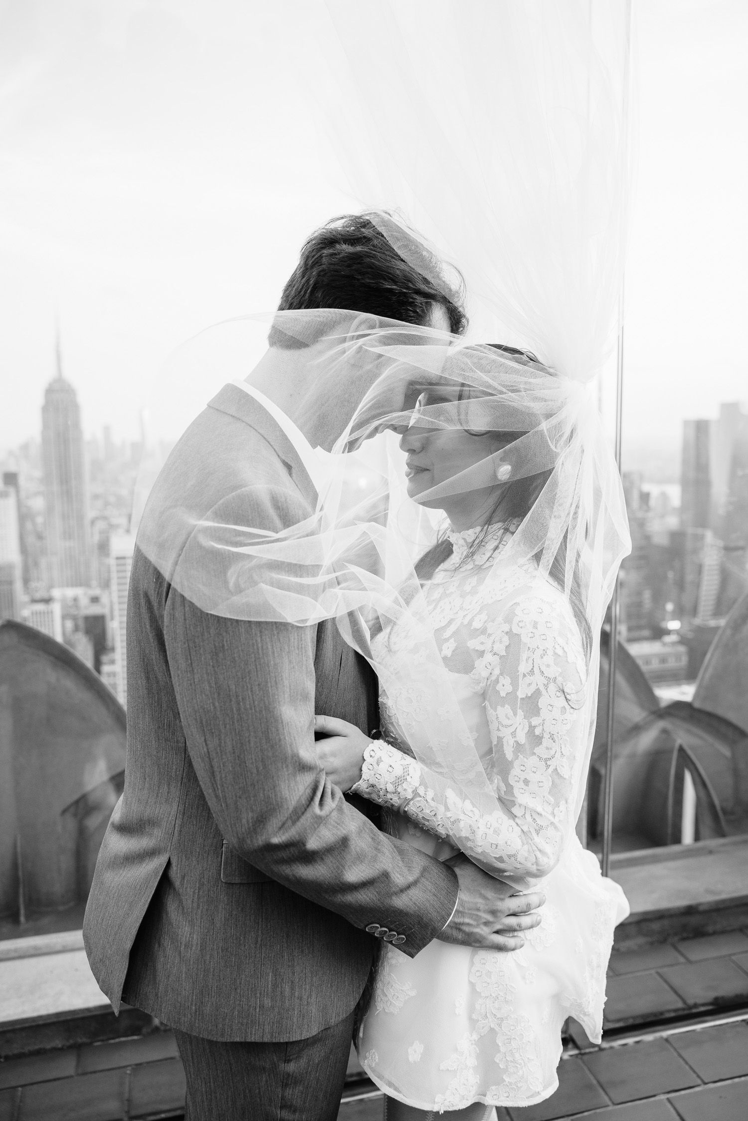 Couple looking at each other under her veil at Top of the Rock in NYC