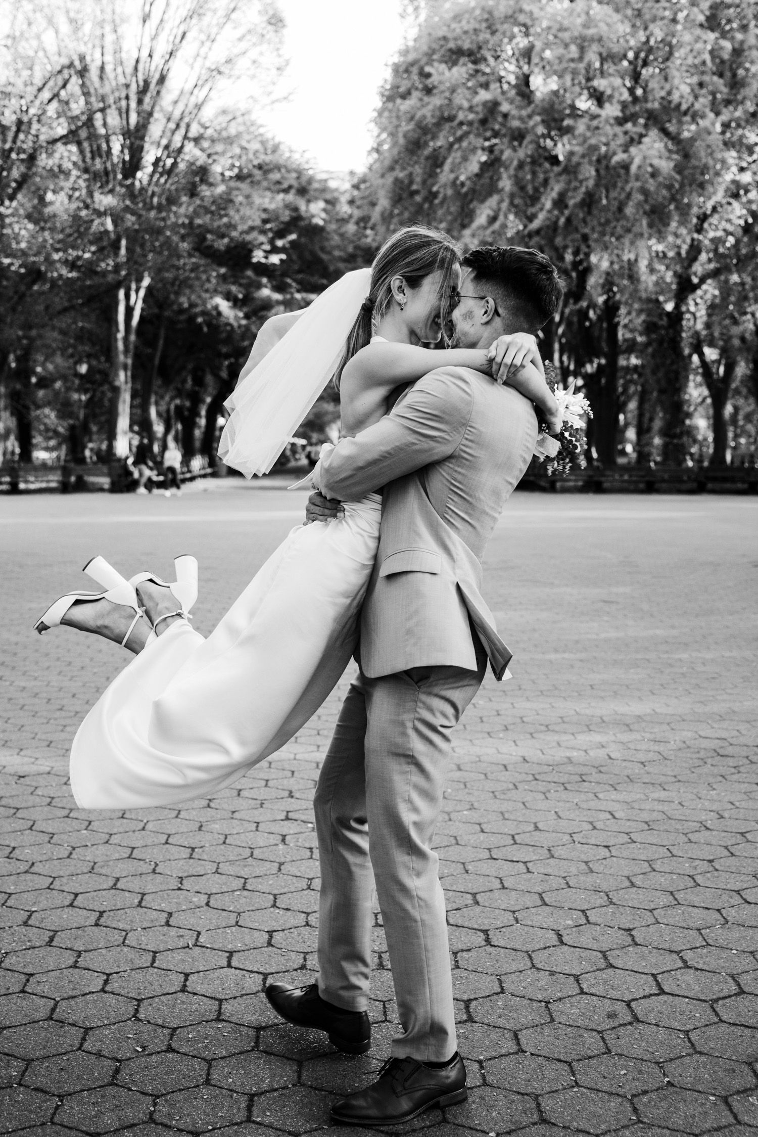 Groom lifting and spinning bride at Bethesda Terrace in Central Park in NYC