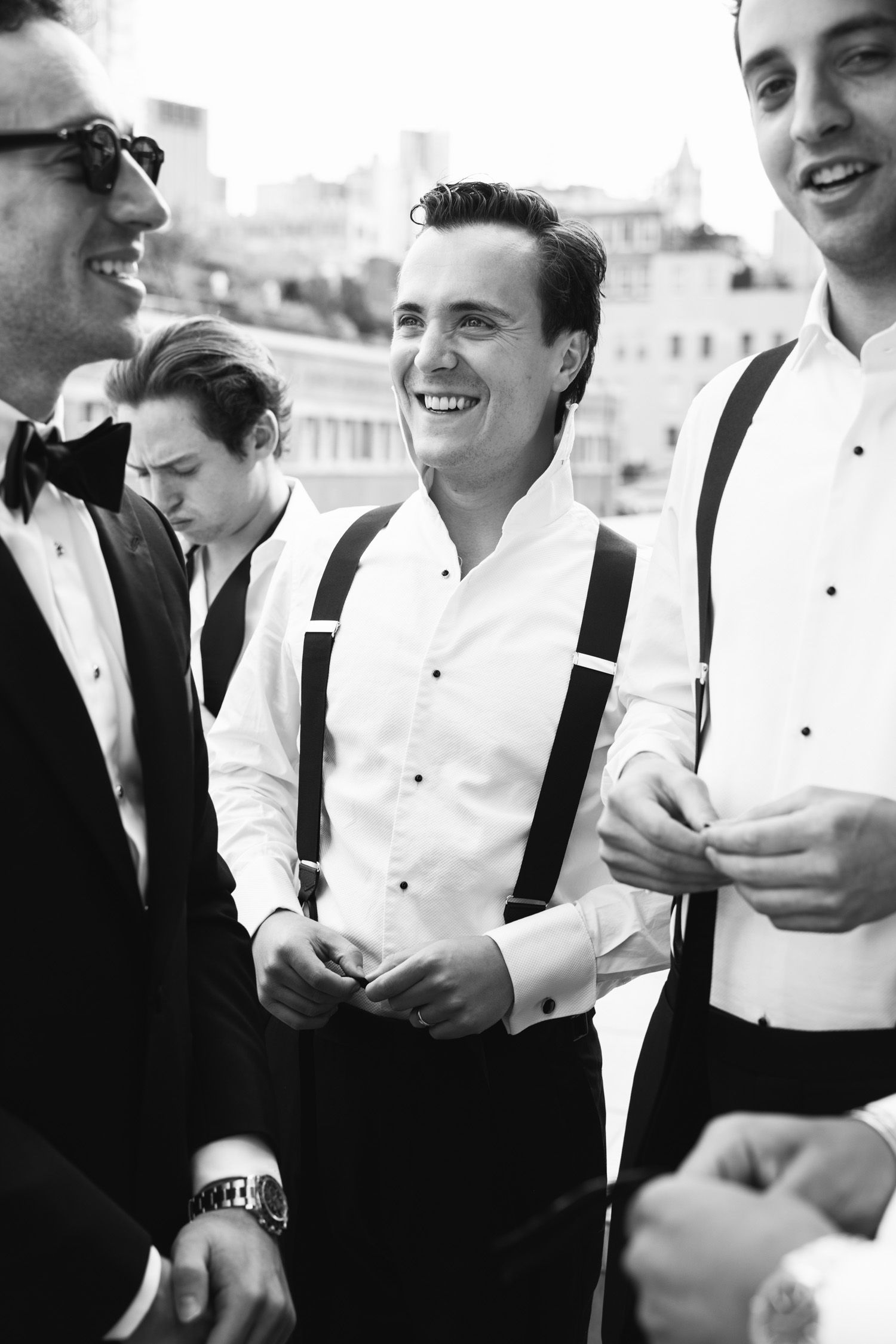 Groom with groomsmen laughing as they get ready in NYC