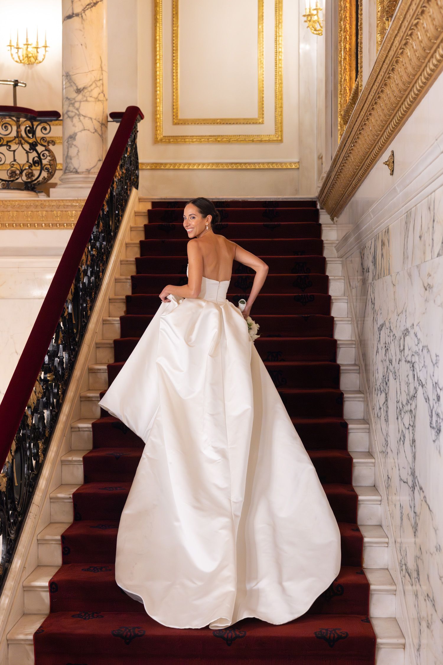 Bride walking up the steps inside the Metropolitan Club in NYC