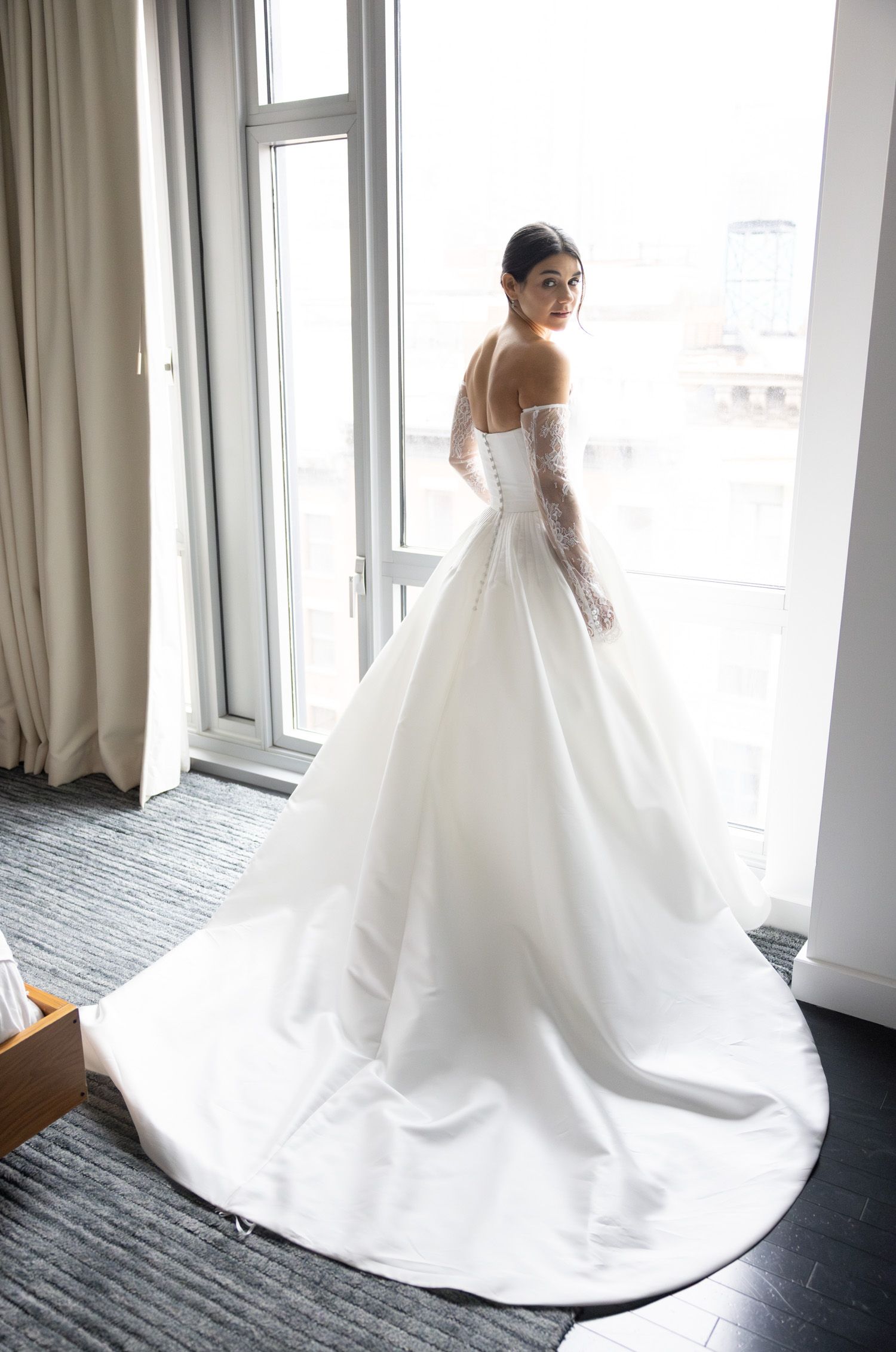 Bride looking over her shoulder after getting dressed before her wedding in NYC