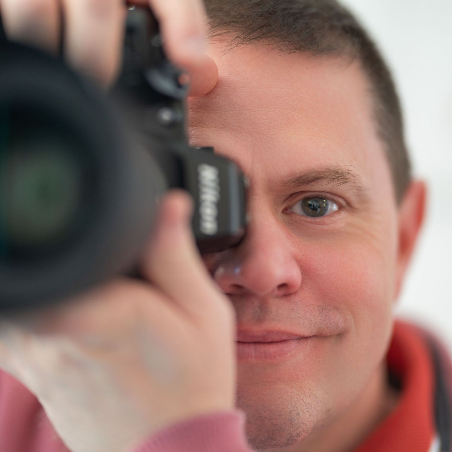 A sequence of close-up portraits showing a person with Down syndrome expressing joy and smiling at the camera.