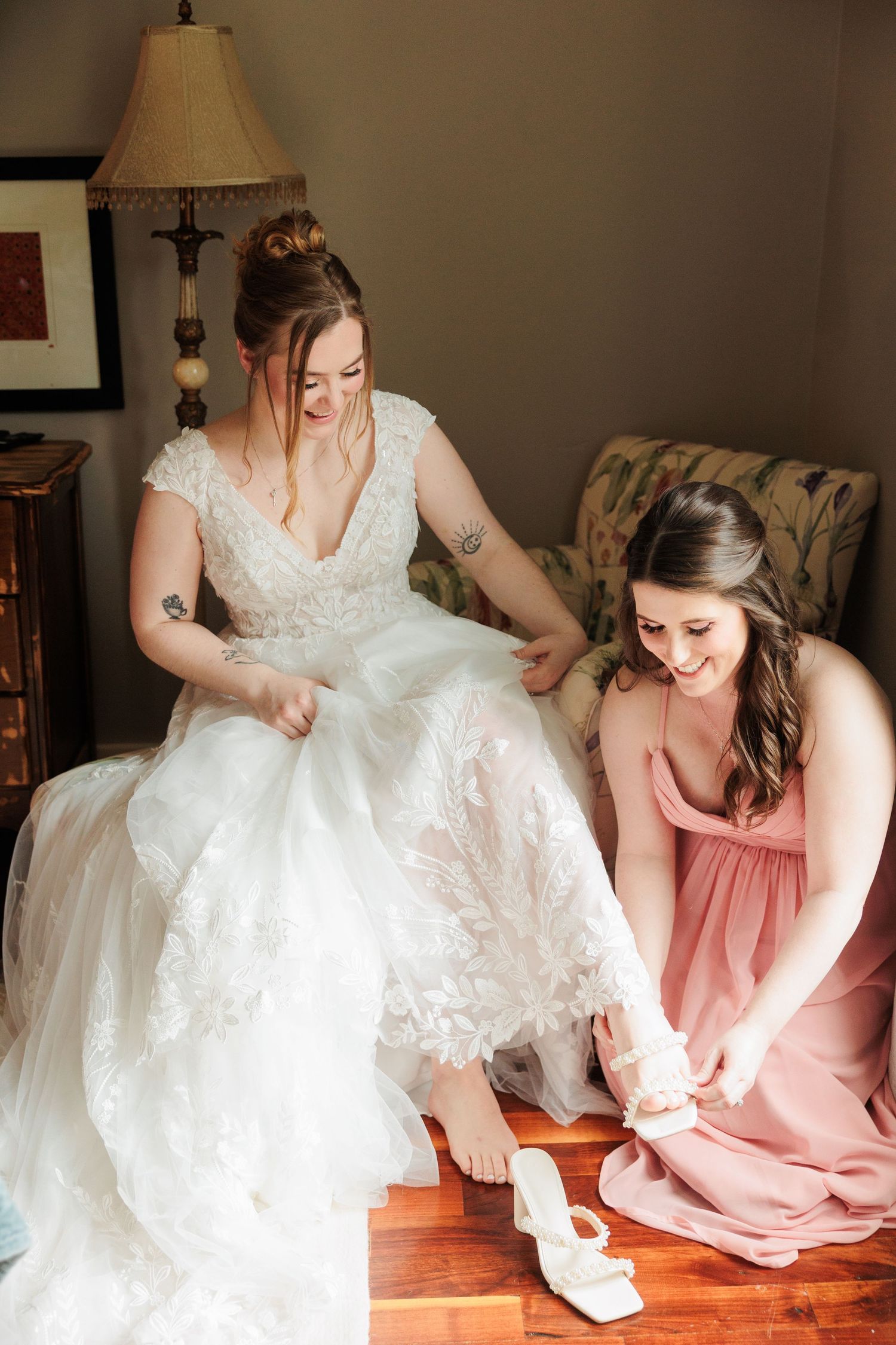 Wedding dress preparation scene with bridesmaids in pink helping with final touches.

Rochester NY wedding photographer
