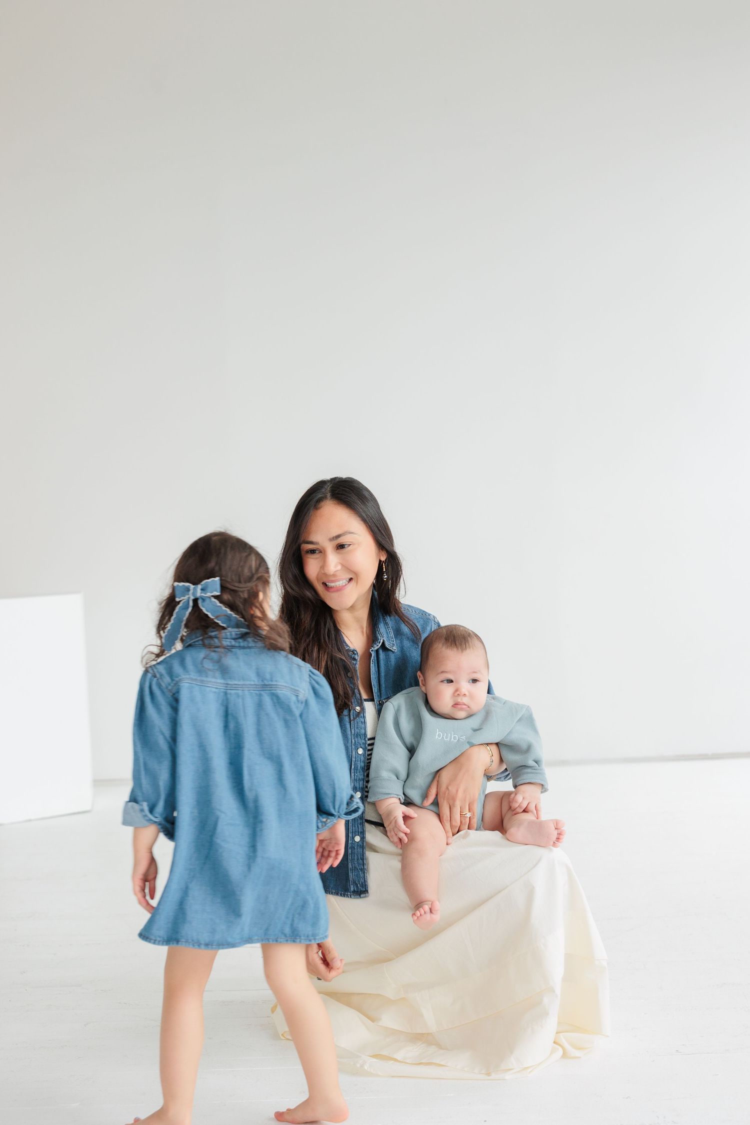 Family playtime scene in a bright white studio with denim and casual attire.

Rochester NY wedding photographer
