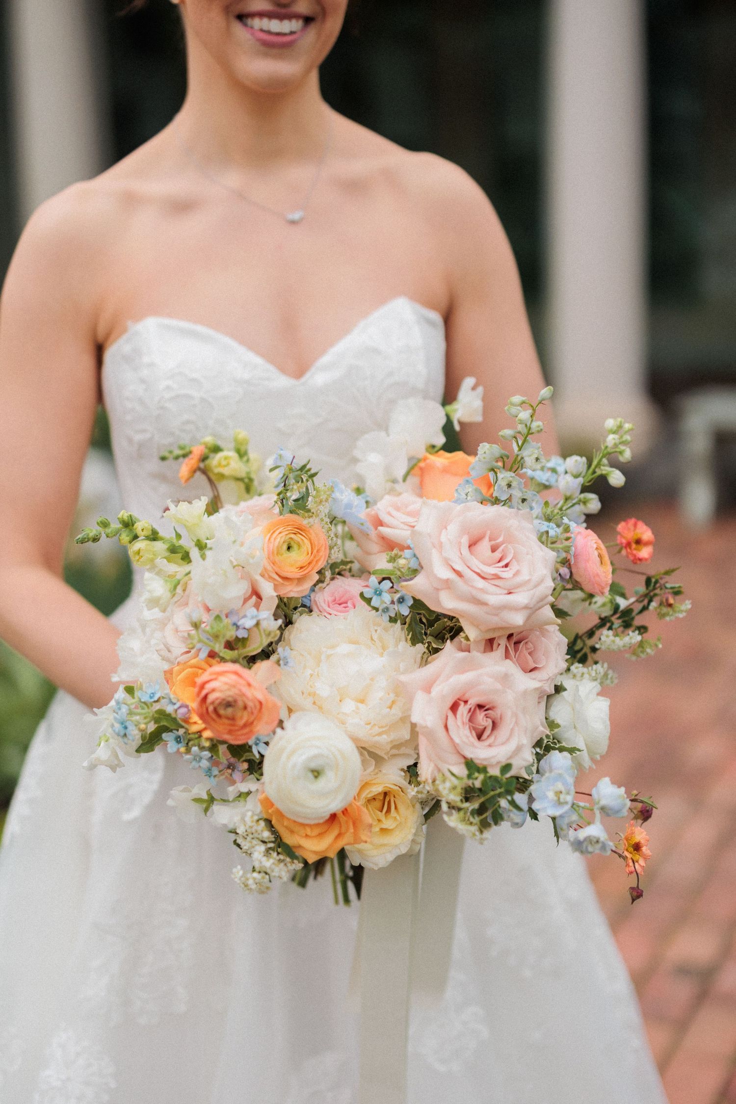 Close-up of pastel wedding bouquets featuring peach, pink and white roses.