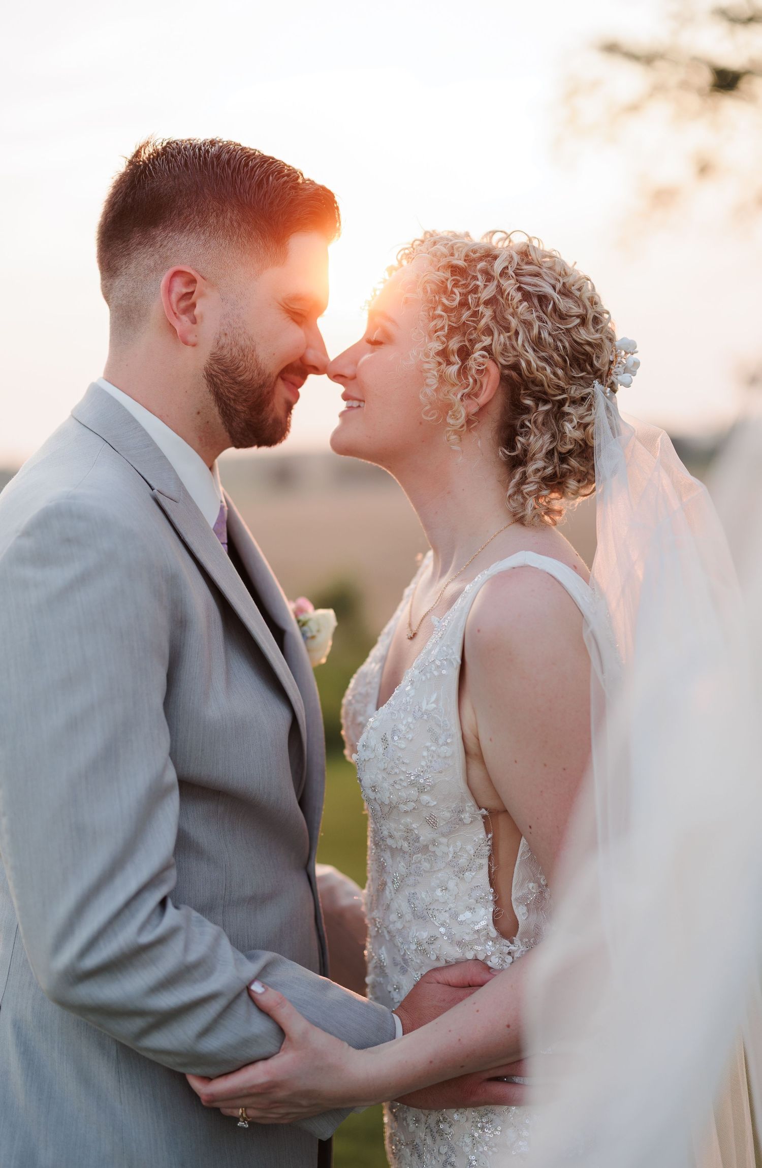 A tender moment between newlyweds during golden hour sunset.