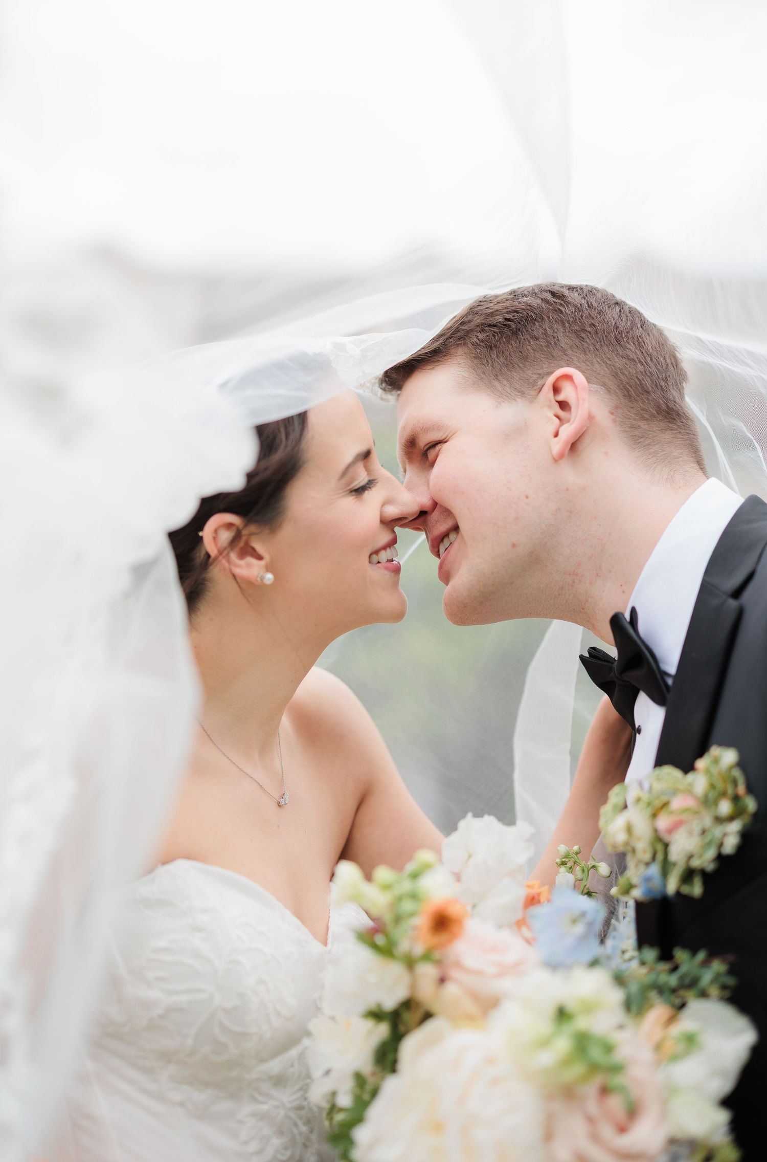Close-up romantic wedding moment with bouquet of peach flowers.