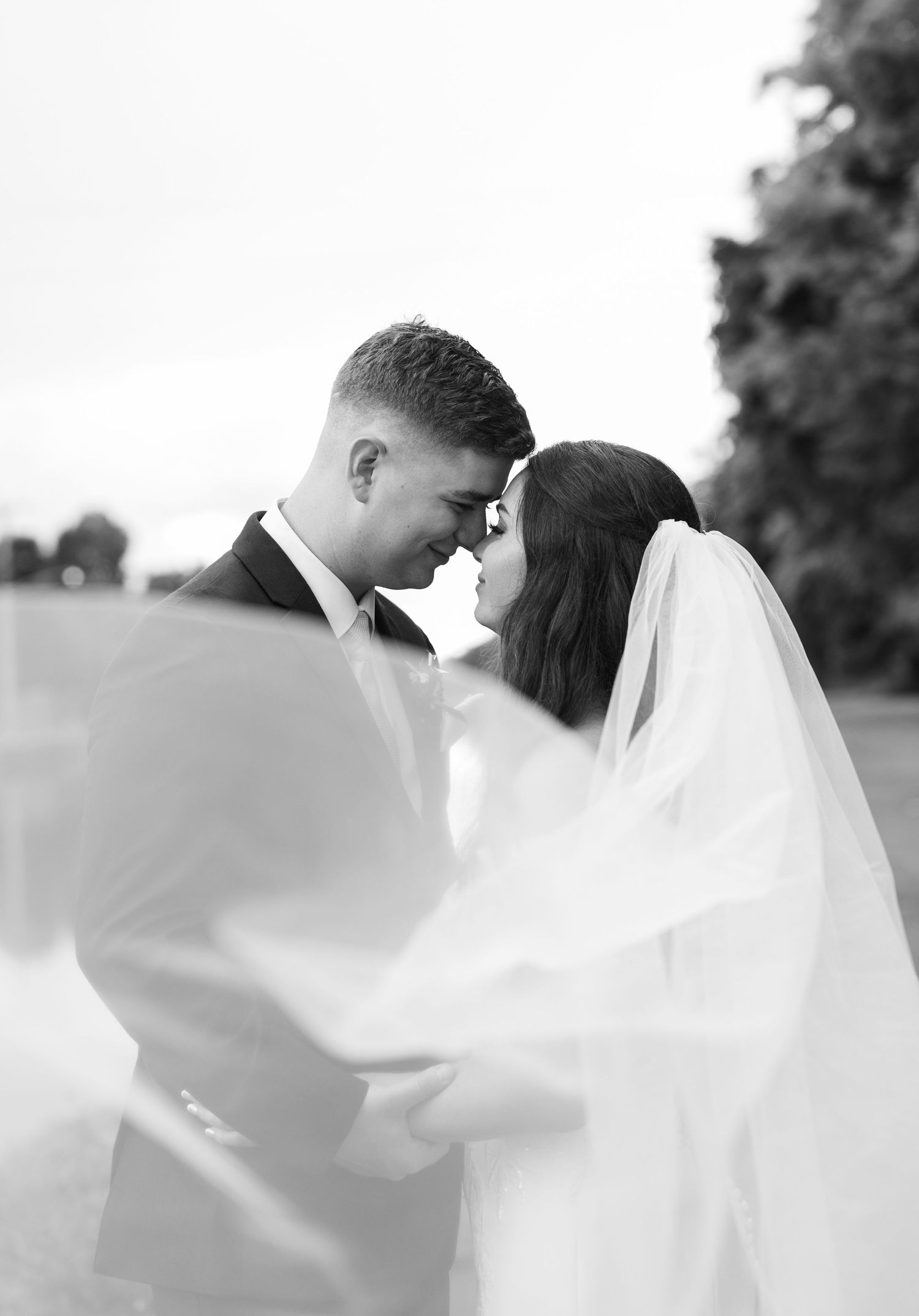 A romantic wedding photoshoot sequence with flowing veil in black and white.