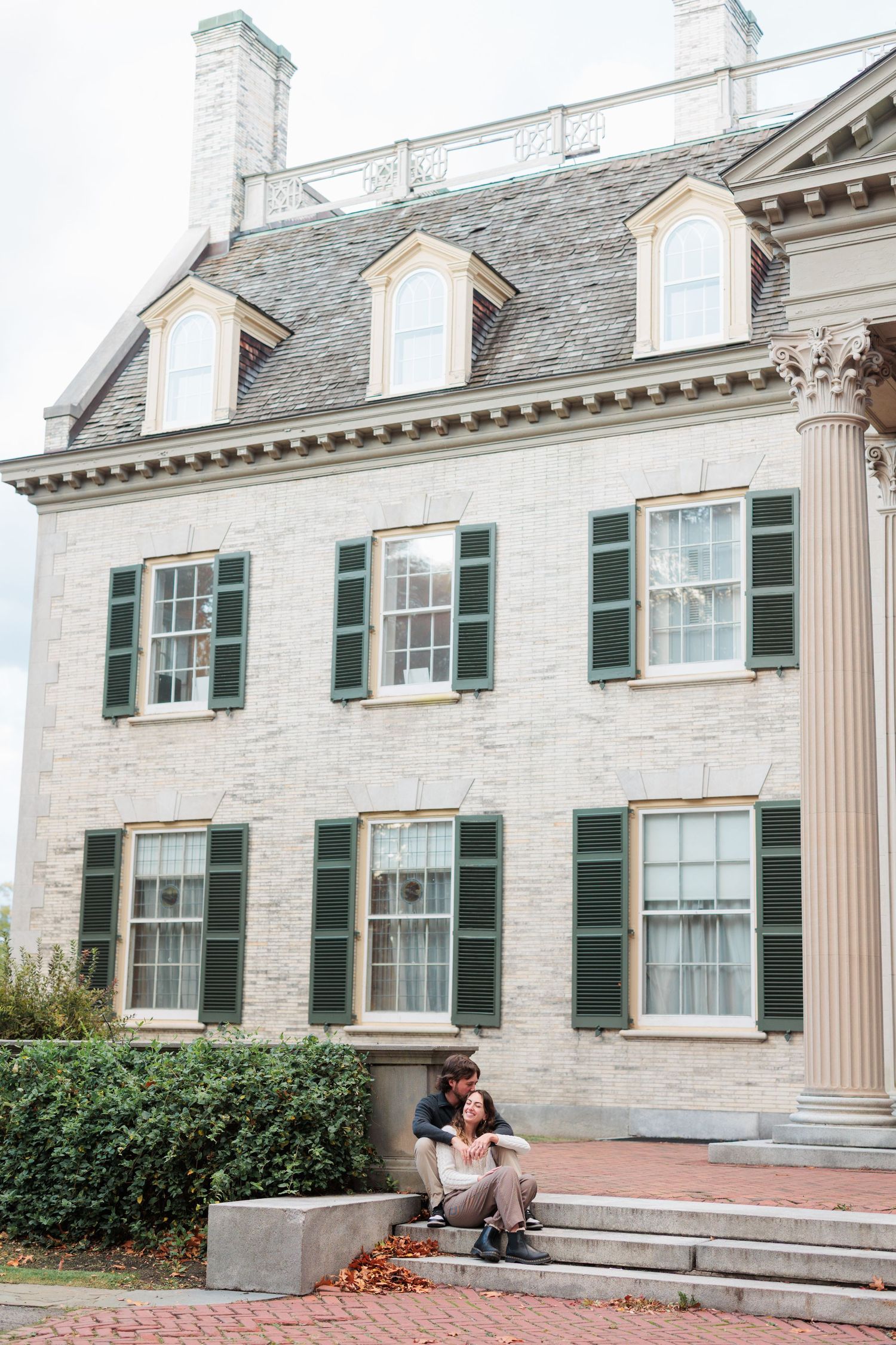 Elegant stone mansion exterior with white columns and green shutters shown from multiple angles in fall season.