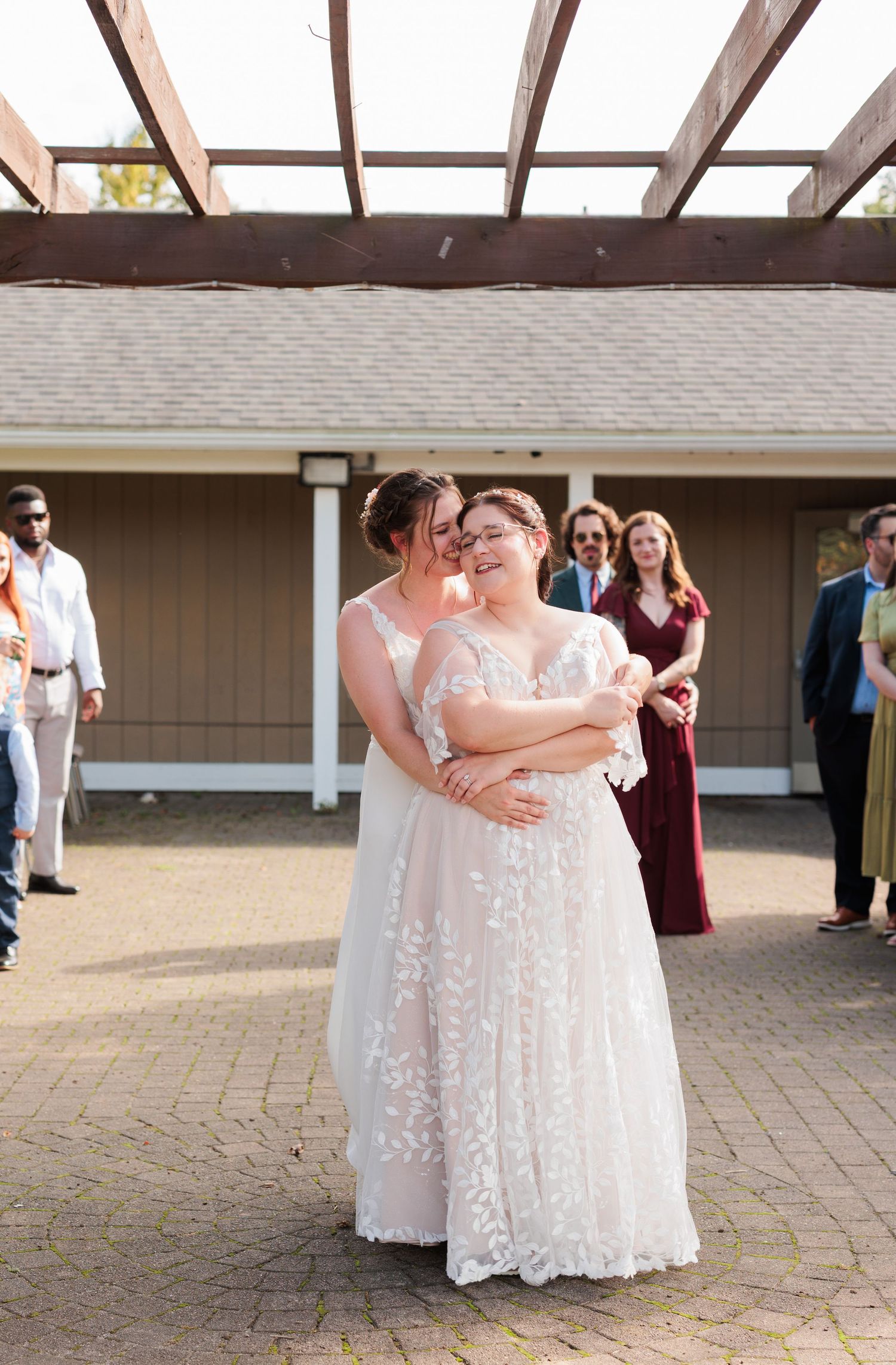 Wedding couple sharing intimate moment under pergola with guests in background.

Rochester NY wedding photographer