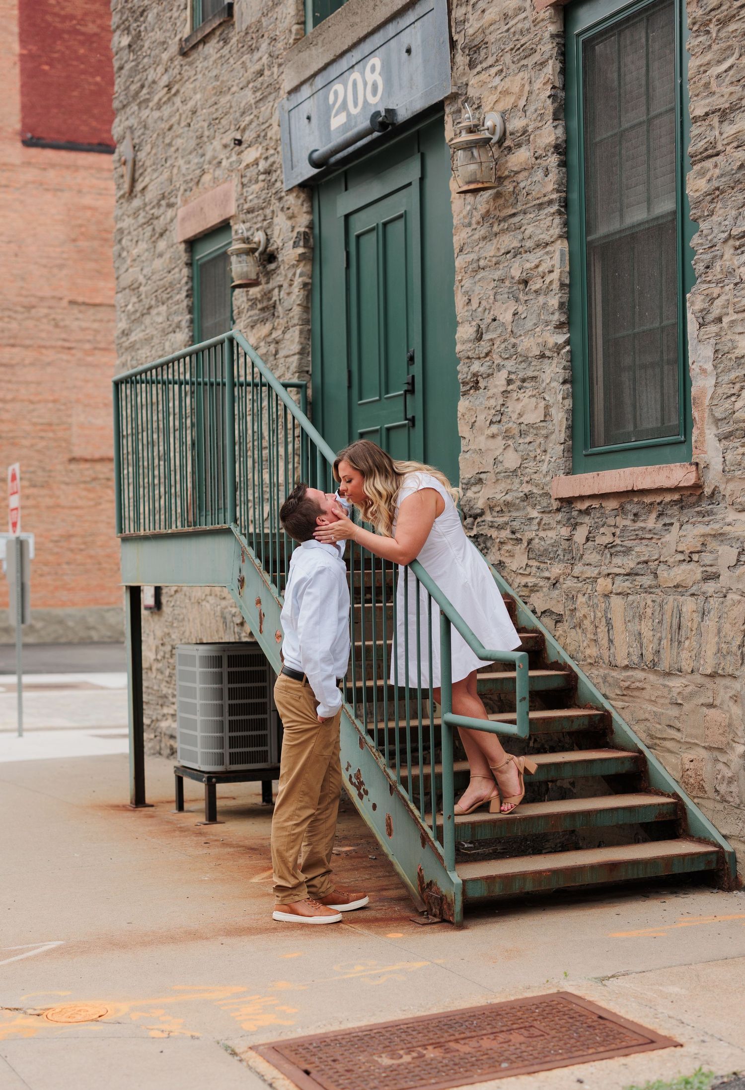 A romantic moment captured on vintage stone steps with green door and industrial architecture.