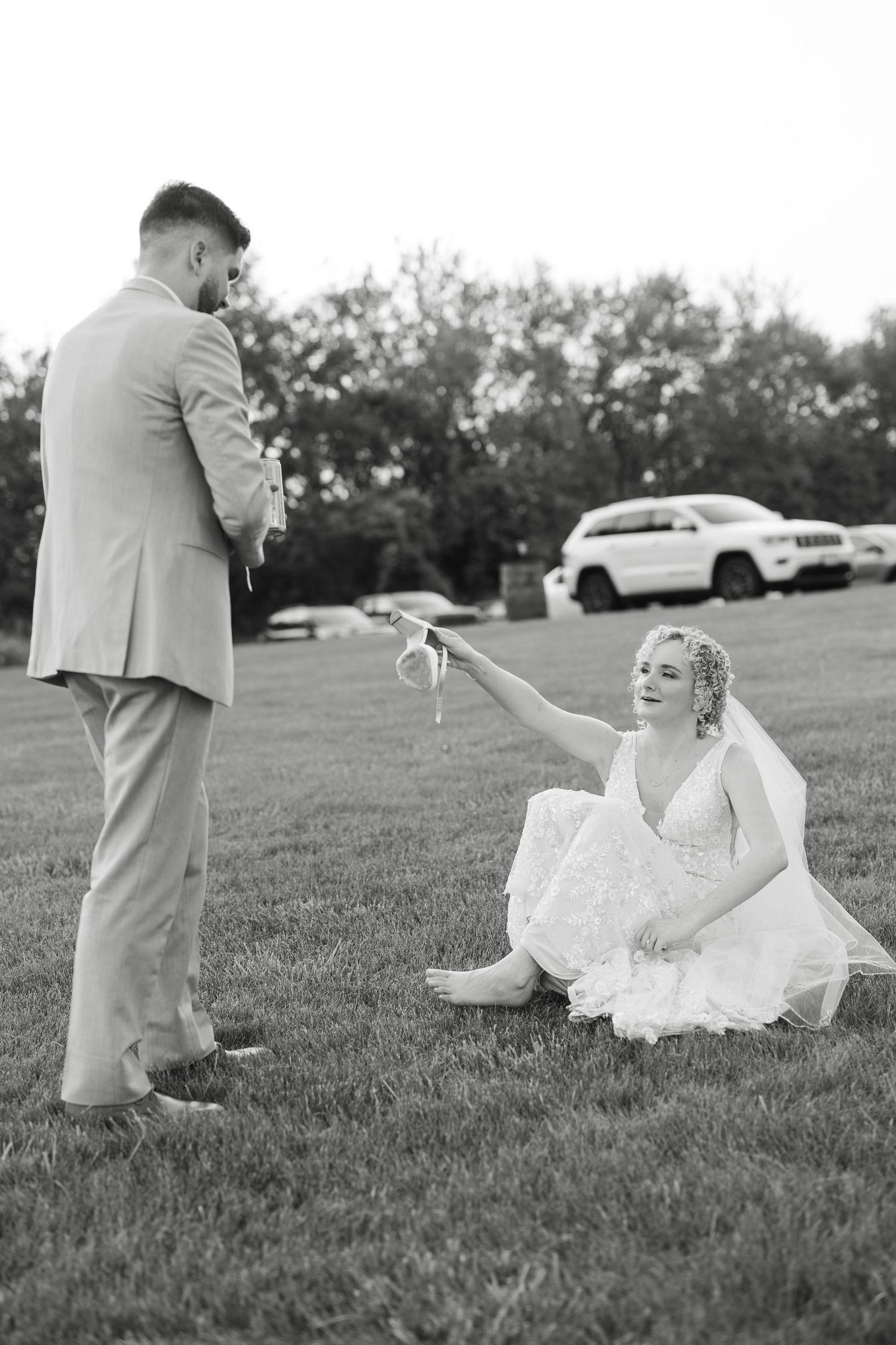 Playful wedding photo sequence taken on grassy field in black and white.