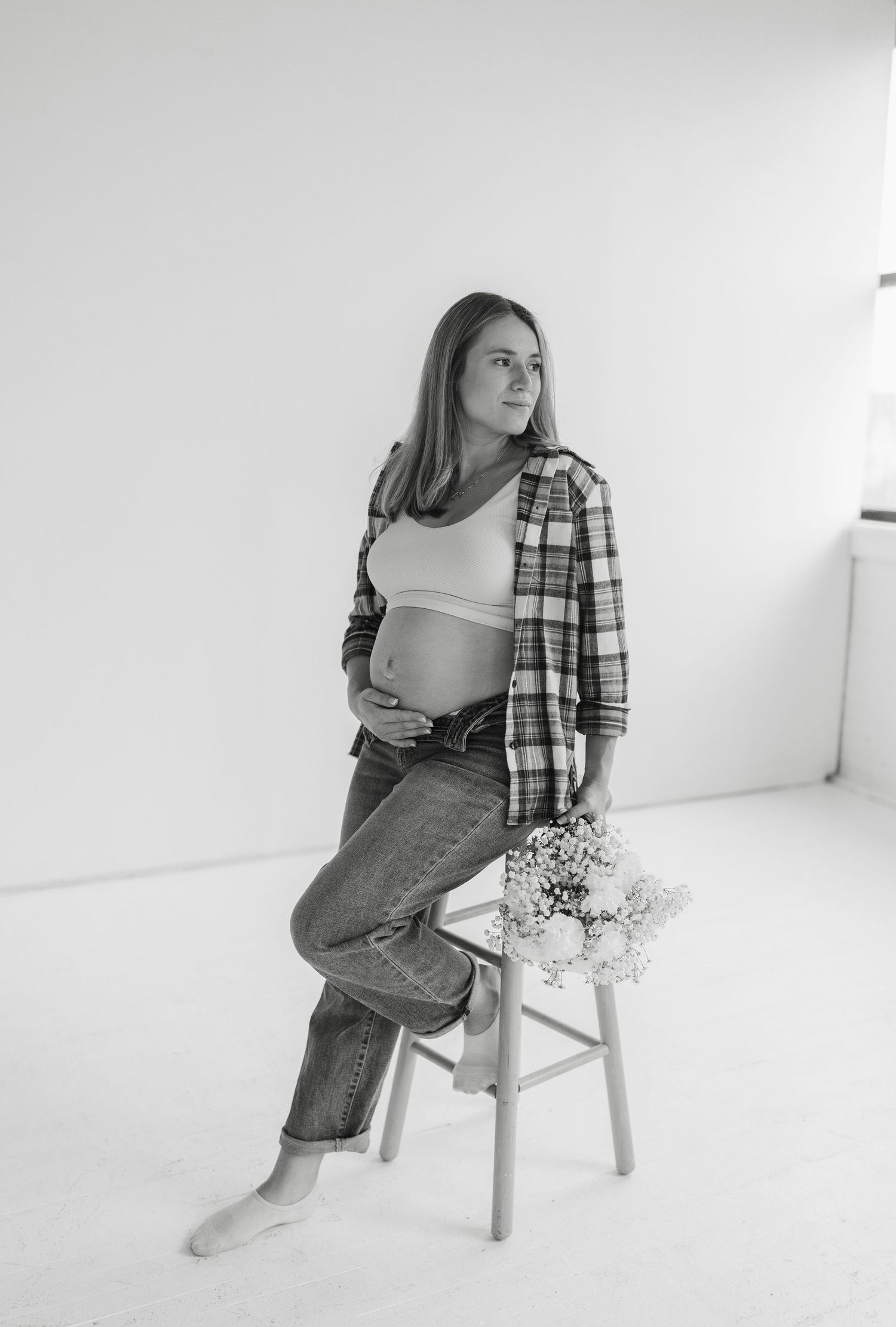 A series of minimalist fashion photos showing someone posing in jeans and plaid shirt against a white studio backdrop.