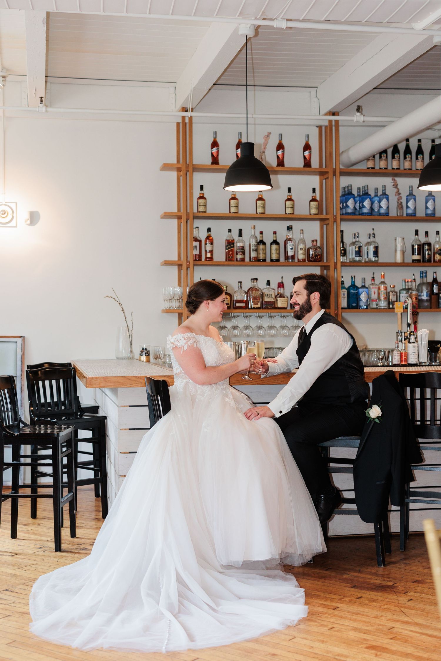 Wedding couple dancing in an intimate bar setting with wooden shelves of bottles.

Rochester NY wedding photographer
