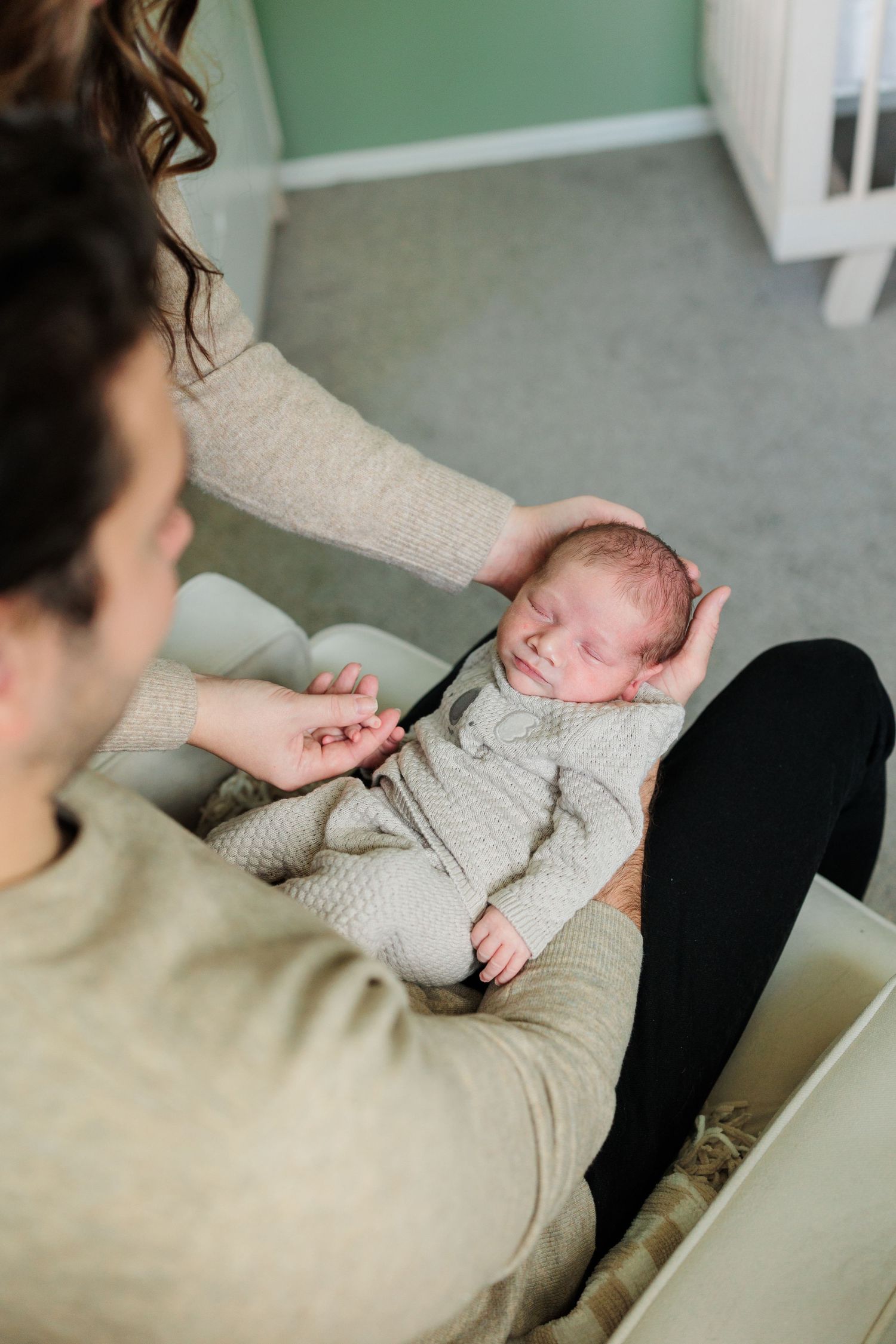 A sleeping newborn baby in a knit outfit being gently touched.

Rochester NY wedding photographer