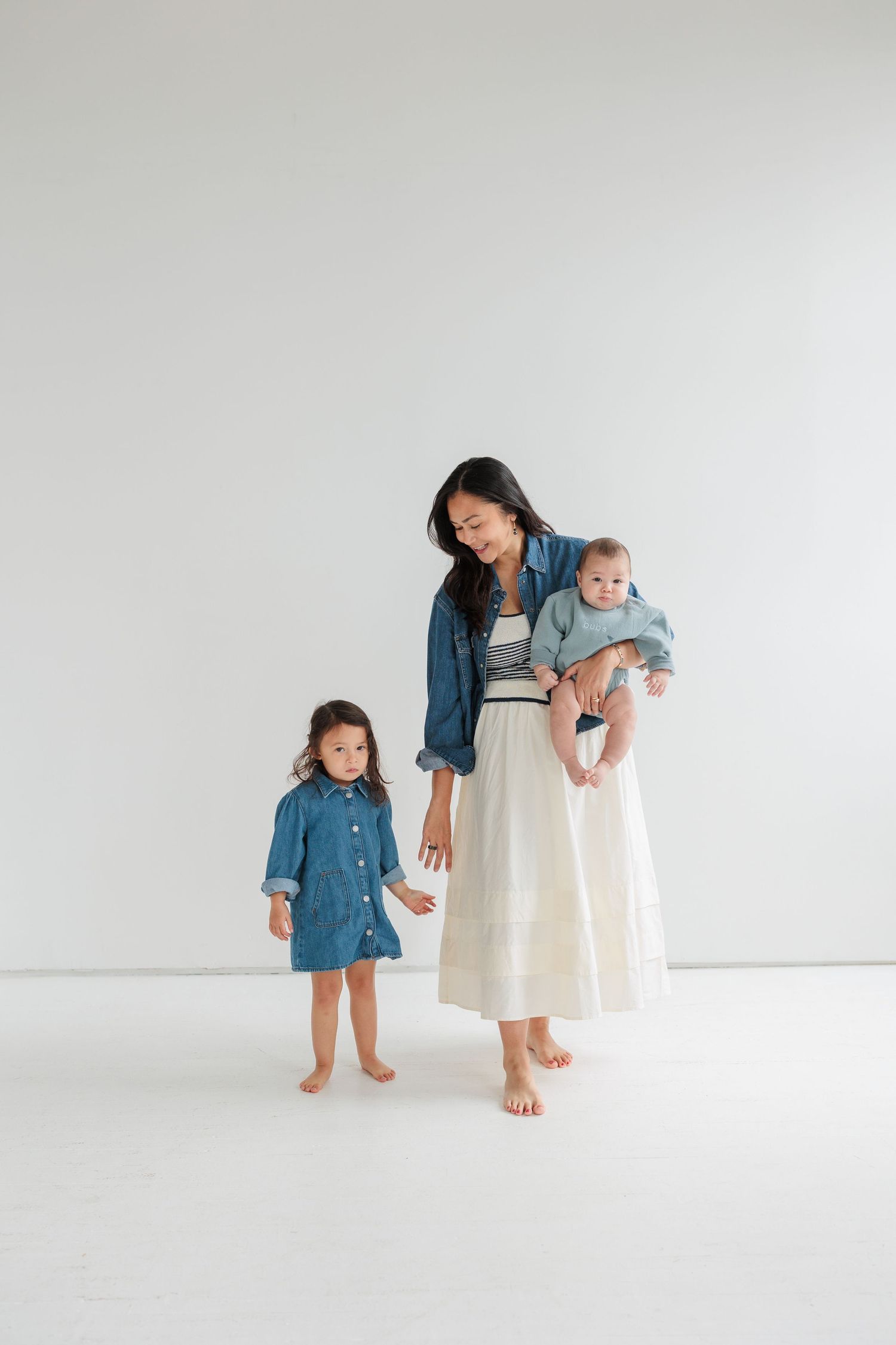 A family in coordinating denim and white outfits poses together against a minimalist white backdrop.

Rochester NY wedding photographer