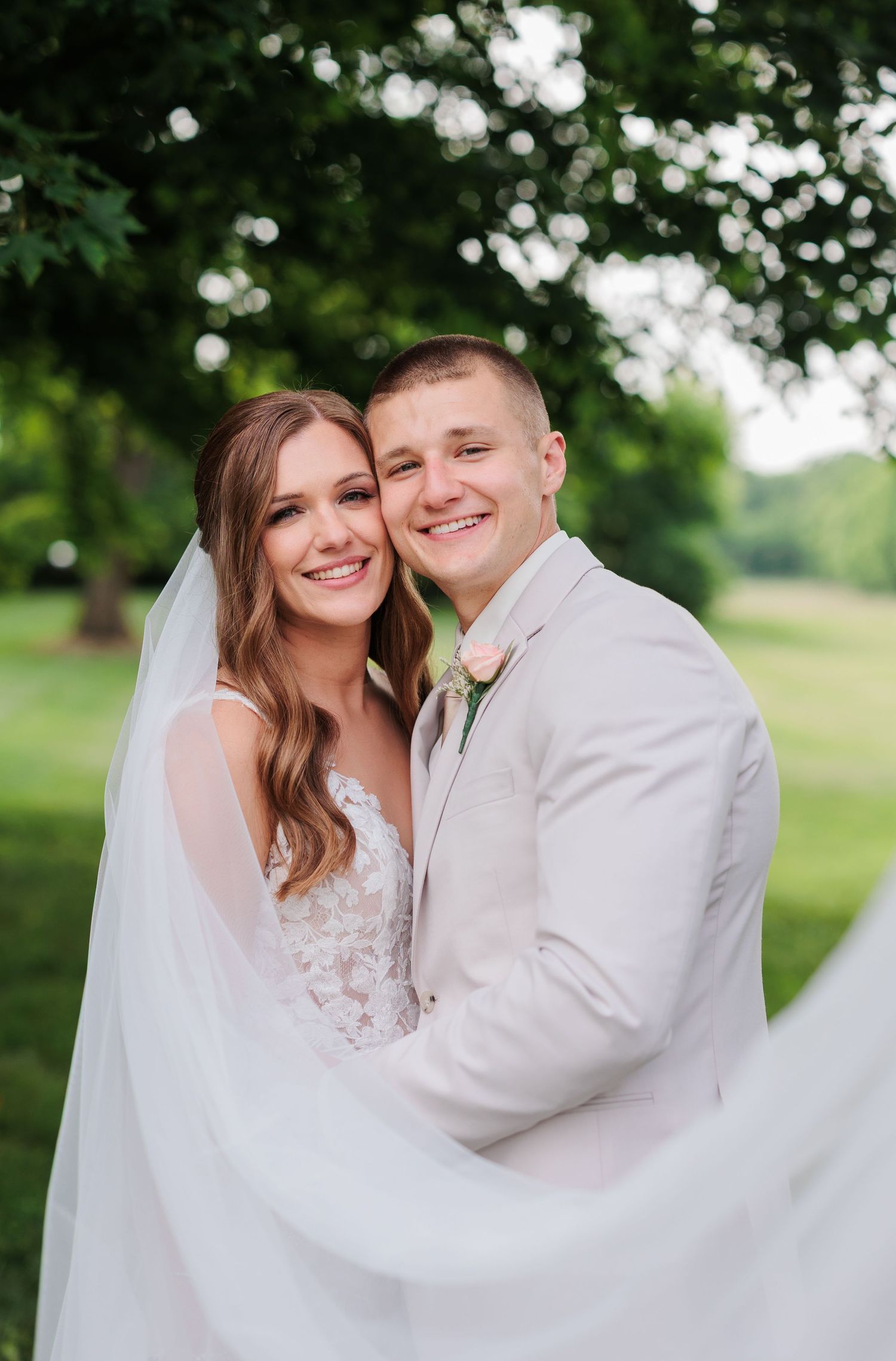 A romantic wedding portrait sequence with a flowing veil in a natural outdoor setting.