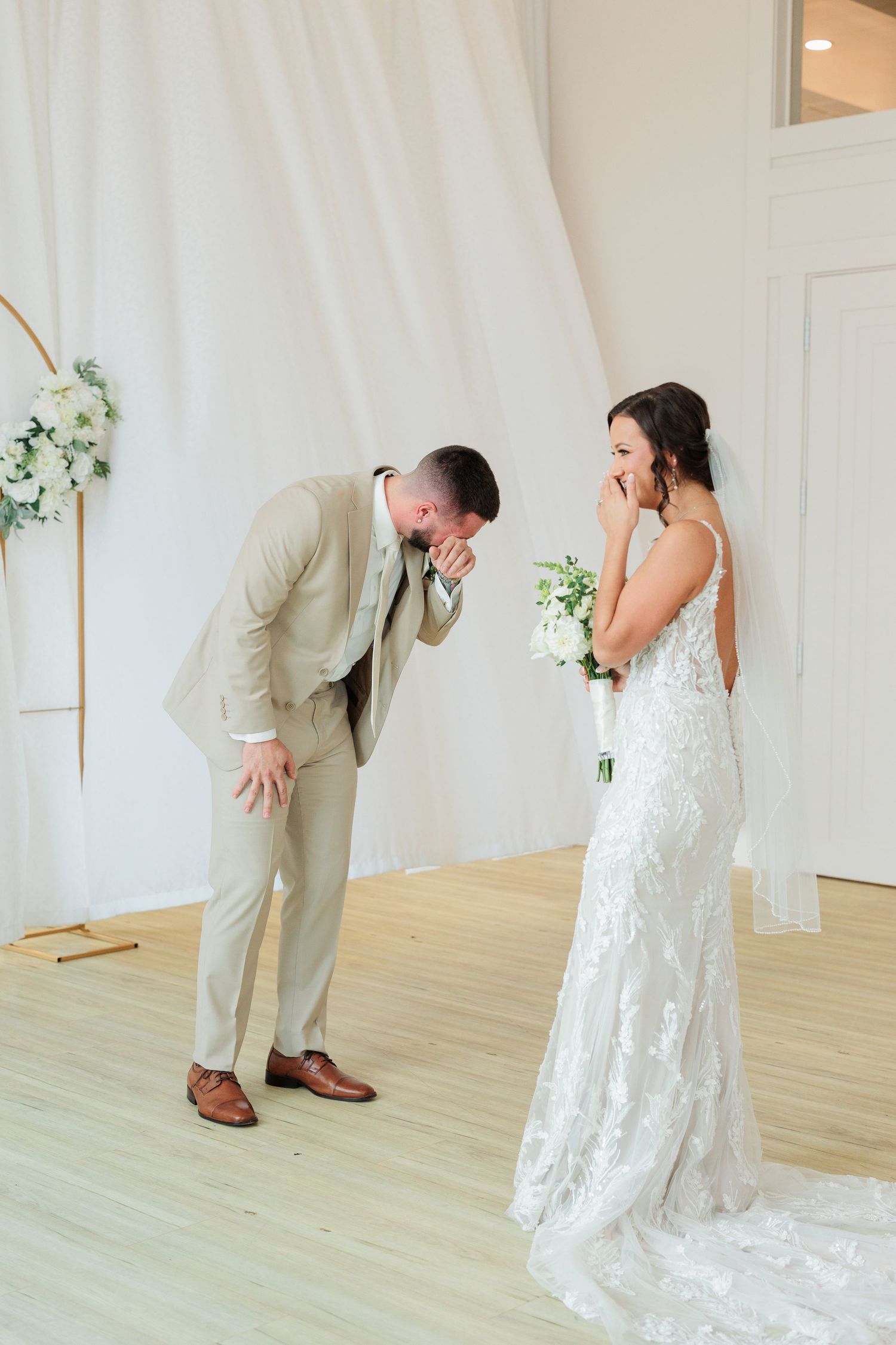 Wedding first look sequence showing emotional reactions between couple in a light-filled studio setting.