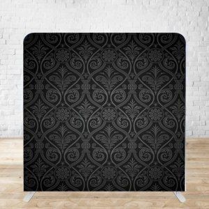 Black damask pattern backdrop with elegant swirling motifs against wooden floor and white brick wall background.