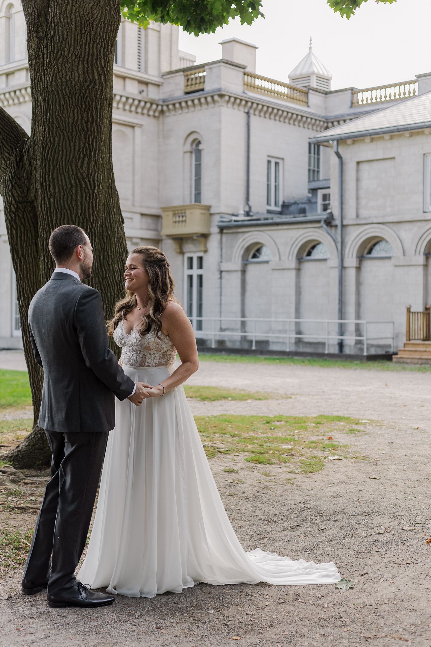 Candid wedding photography of bride and groom during their first look in front of the dundurn castle in hamilton, ontario.