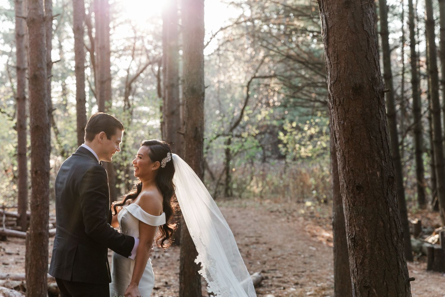 Bride and groom posing under the sunset light amongst the trees at the Kortright Centre in Vaughan, Ontario