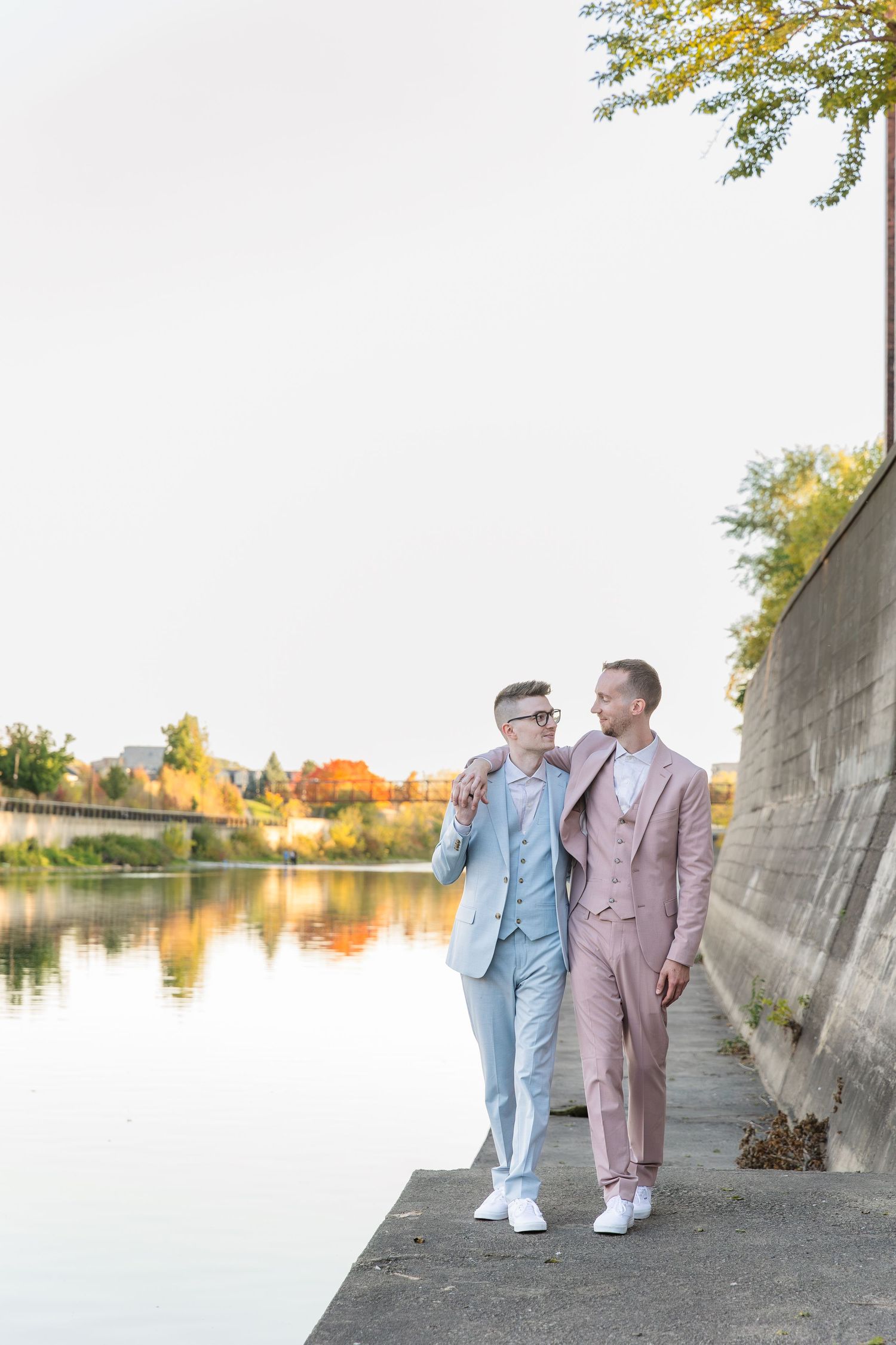 Candid wedding photography of grooms walking along the river during sunset in downtown galt in Cambridge, Ontario.