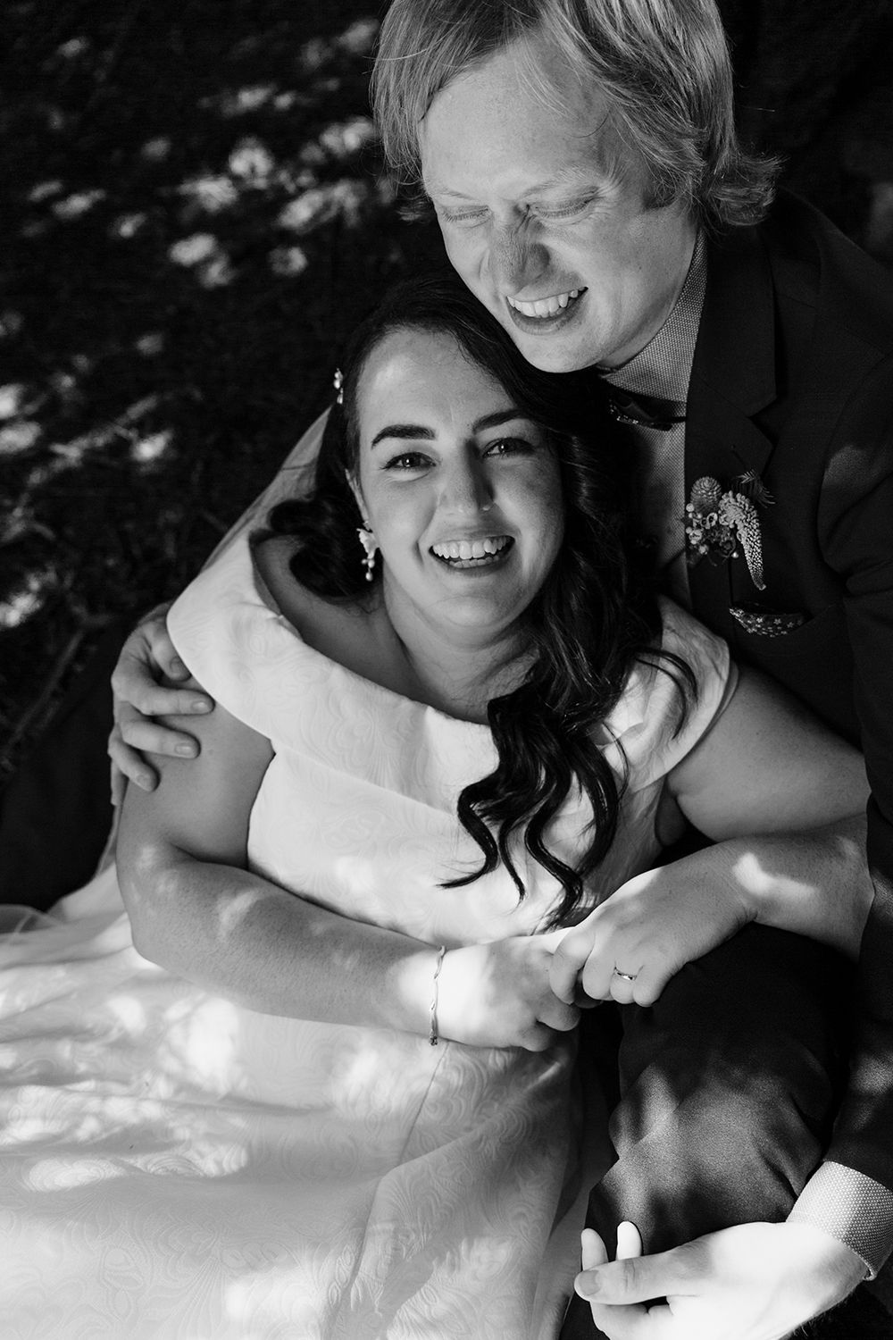Black and white portrait of a happy couple sharing a joyful moment together at their wedding celebration.