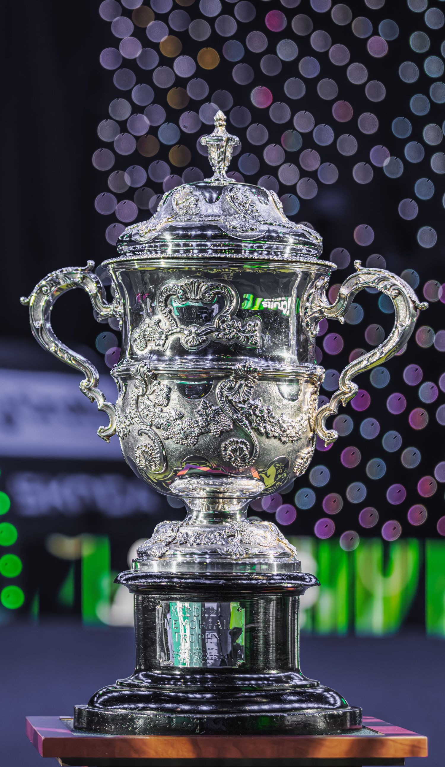 The Norman Brookes Challenge Cup trophy for the Australian Open tennis tournament displayed from different angles in dramatic lighting.