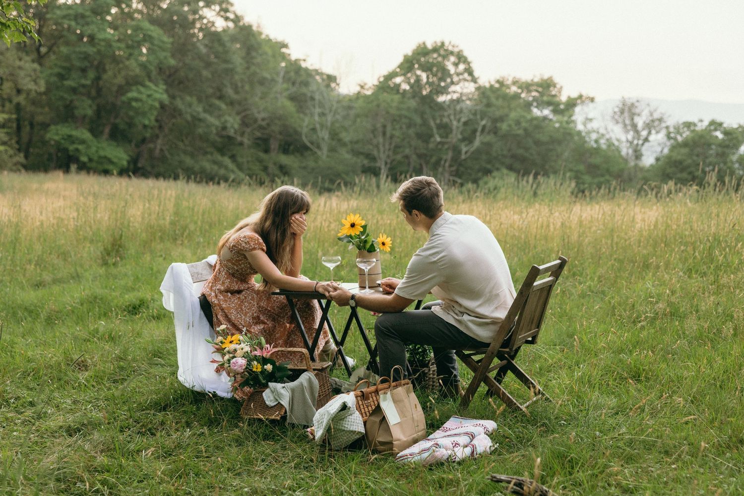 A romantic outdoor picnic setup in a meadow with wooden furniture and sunflowers. Separk Mansion Wedding Photographer
