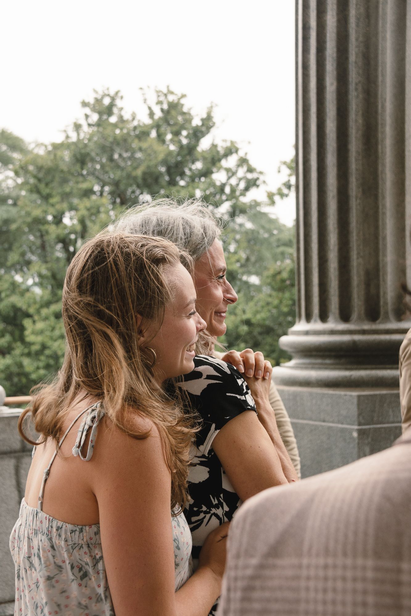 People enjoying a moment together on a columned porch during golden hour. Story-driven wedding photos
