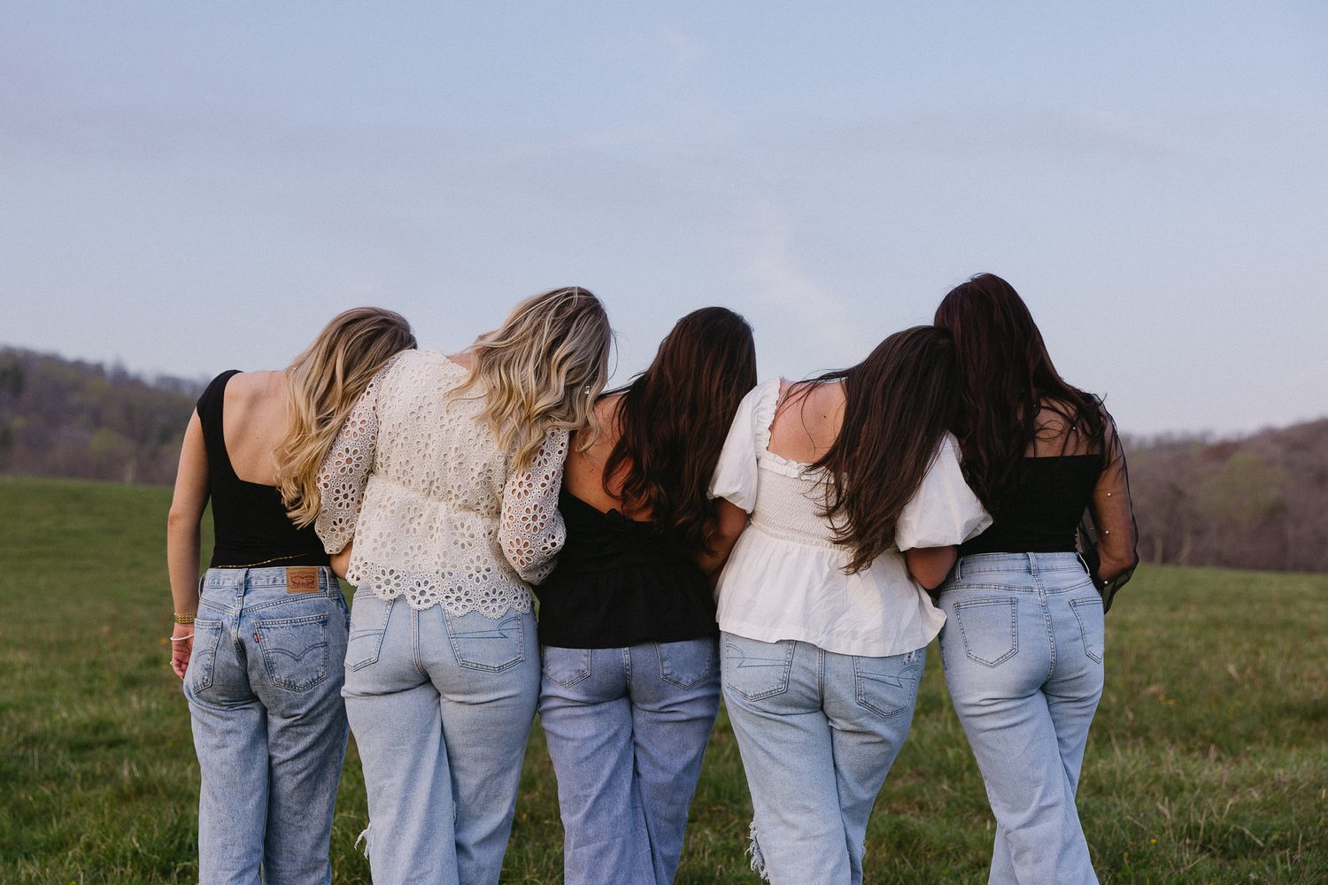 Group photo showing row of people from behind wearing jeans against natural backdrop. The Bradford, Separk  Mansion, Graylyn Estate