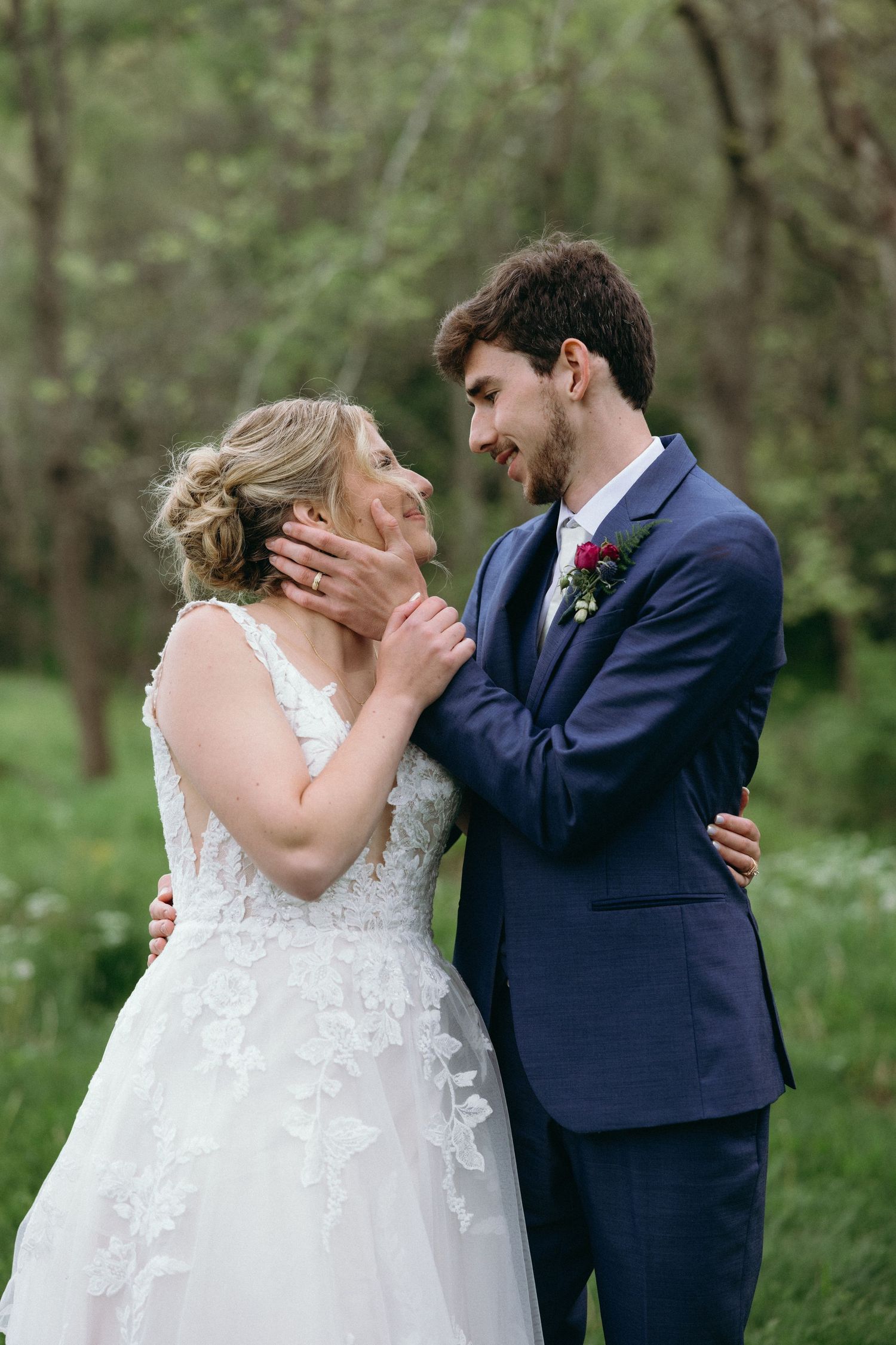 A romantic wedding photo sequence shows a couple in navy suit and white lace dress sharing tender moments in a wooded setting. photographer