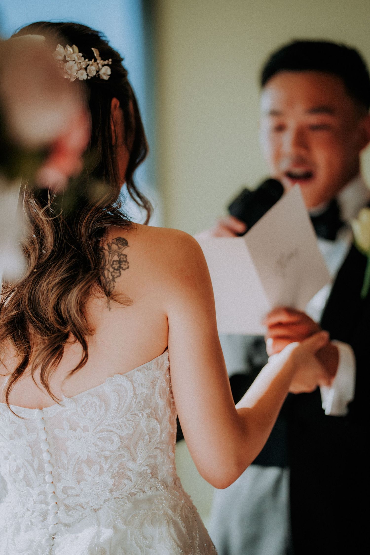 Wedding ceremony moment showing exchange of vows with bride in lace dress.