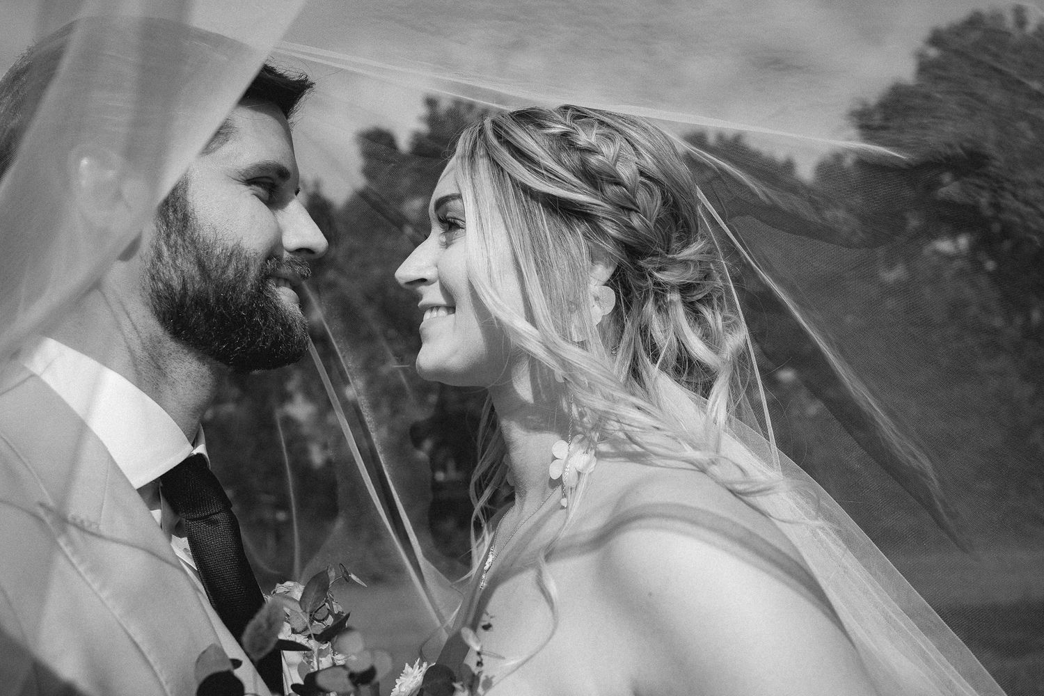 A romantic black and white wedding photo collage showing intimate moments between newlyweds in an outdoor setting.
