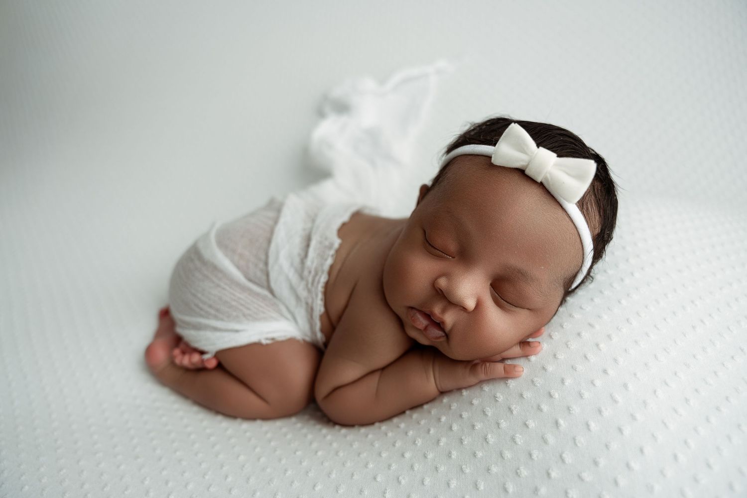 A series of peaceful newborn baby photos showing sleeping poses on white textured backgrounds. – newborn photographer Paloma Schell Houston