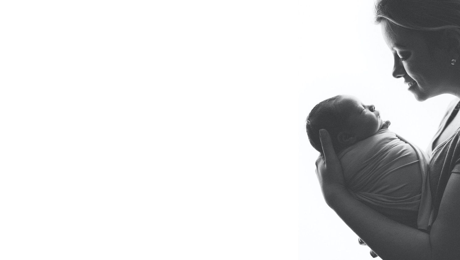 Houston newborn photographer Paloma Schell holding a baby in a black and white silhouette portrait, professional studio session in Katy / TX