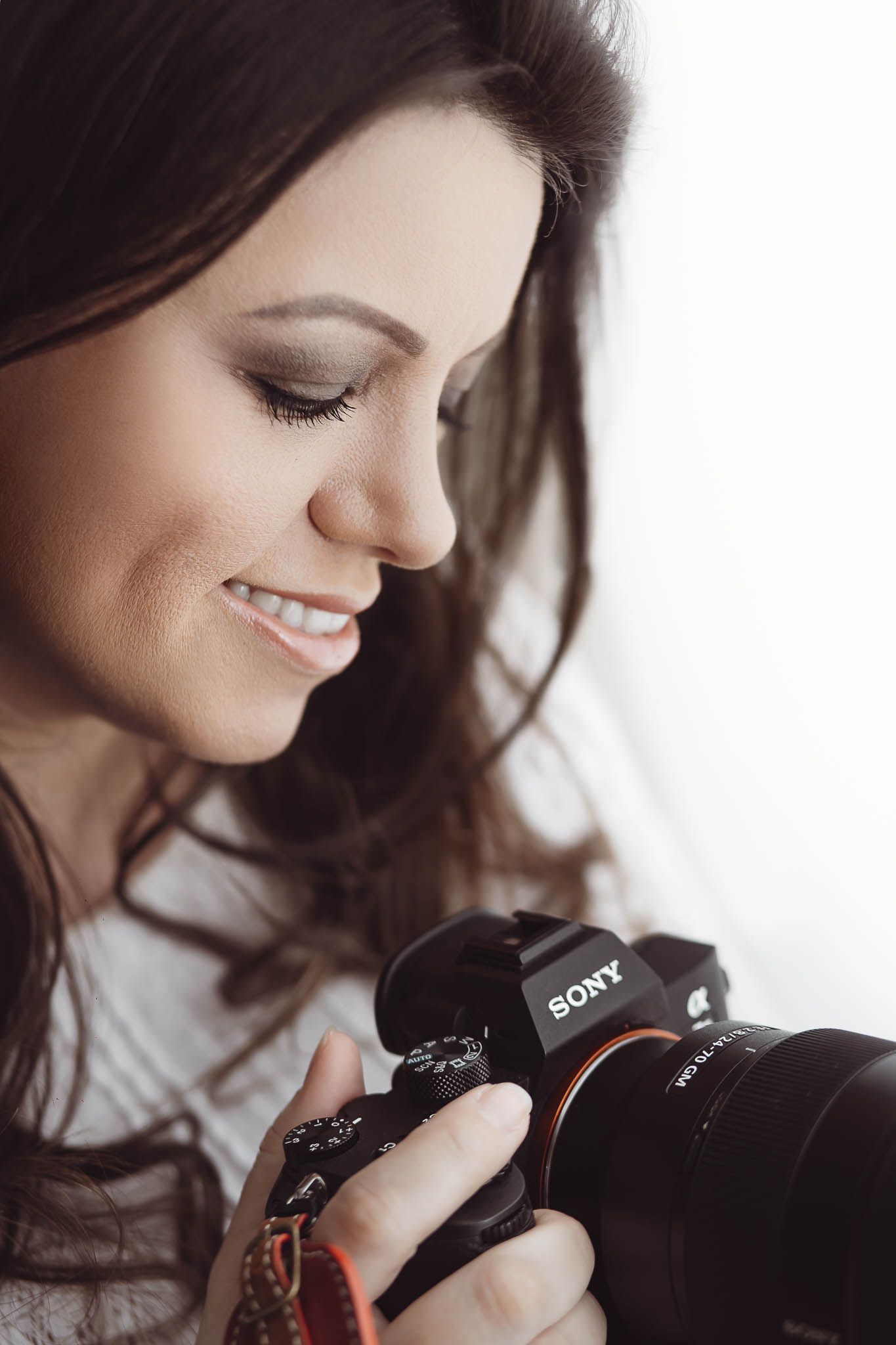 Close-up profile shots of a photographer with dark hair looking through a Sony camera viewfinder.