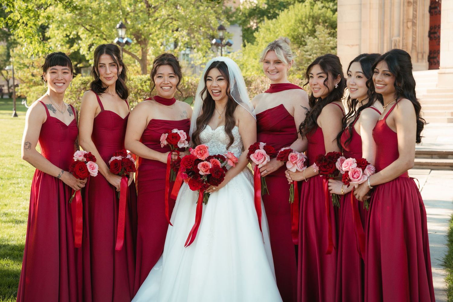 Bride posing with bridesmaids during an outdoor wedding portrait.